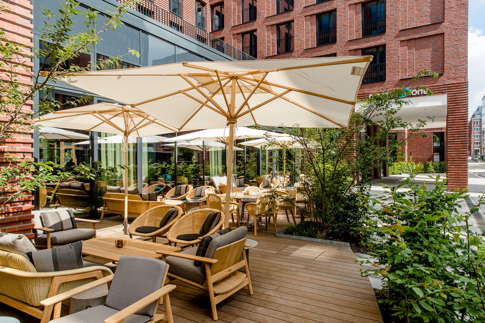 Hotel Hamburg Fleetinsel Motel One Terrasse mit mehreren Sitzgelegenheiten sowie Sonnenschirmen