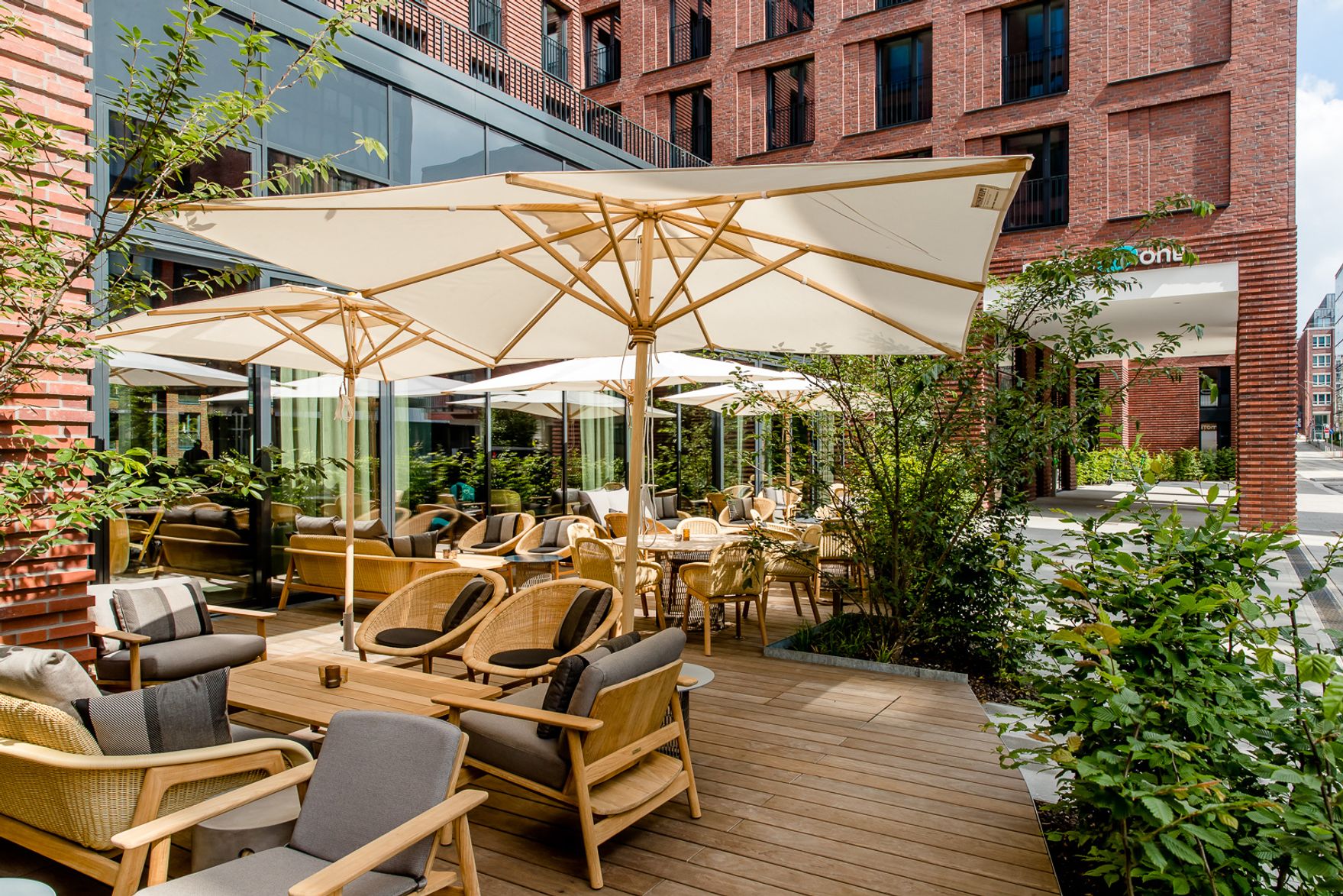 Hotel Hamburg Fleetinsel Motel One Terrasse mit mehreren Sitzgelegenheiten sowie Sonnenschirmen