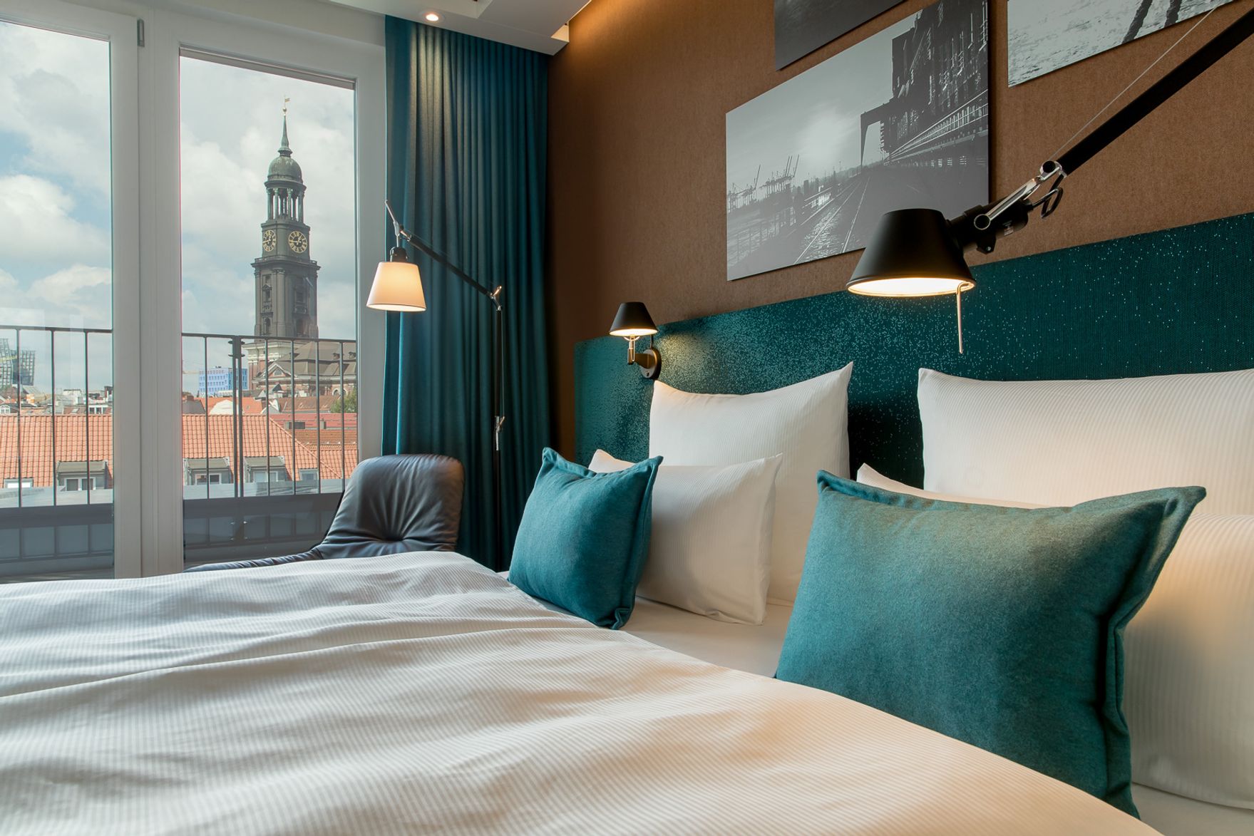 Hotel Hamburg Fleetinsel Motel One seitlicher Blick über Doppelbett durch bodentiefes Fenster mit Aussicht auf die Stadt