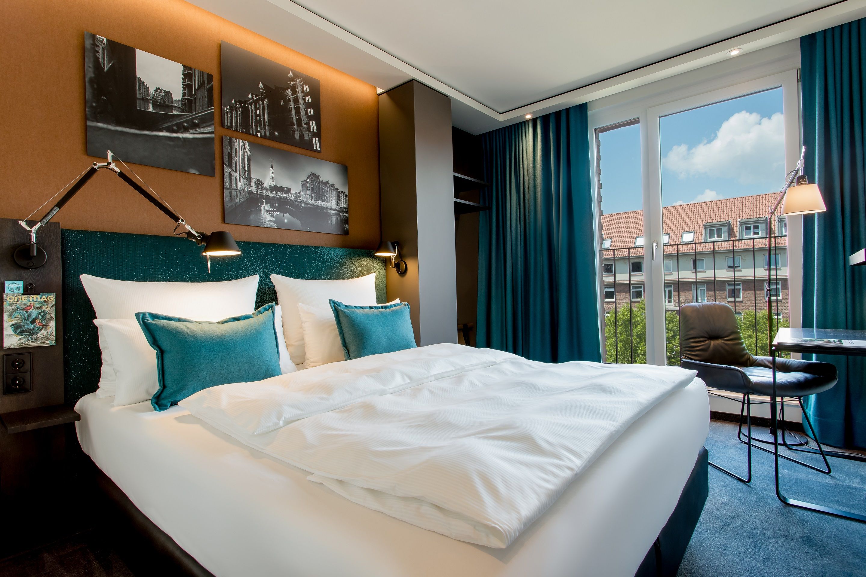 Hotel Hamburg Fleetinsel Motel One lichtdurchflutetes Zimmer mit Doppelbett, Schreibtisch und Stuhl