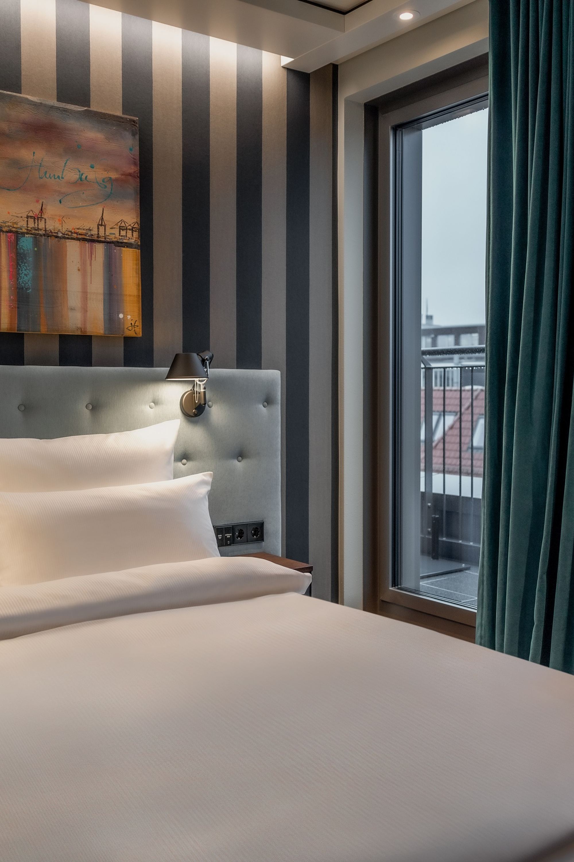 Hotel Hamburg Kontorhaus The Cloud One Zimmer mit großem Doppelbett, Gemälde über dem Bett sowie Balkonzugang