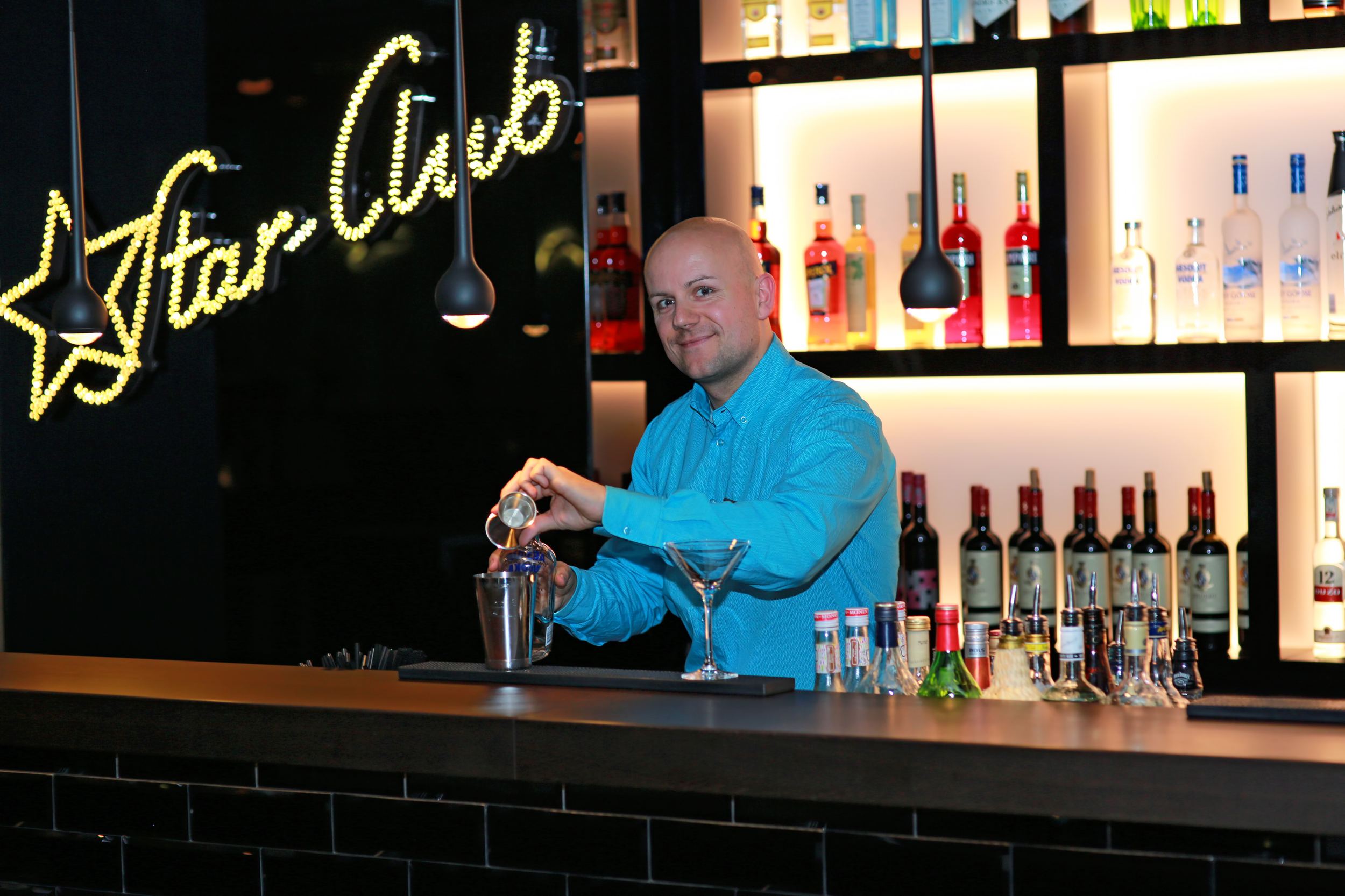 Hotel Hamburg am Michel Motel One Barkeeper hinter der Bar bei der Zubereitung eines Drinks