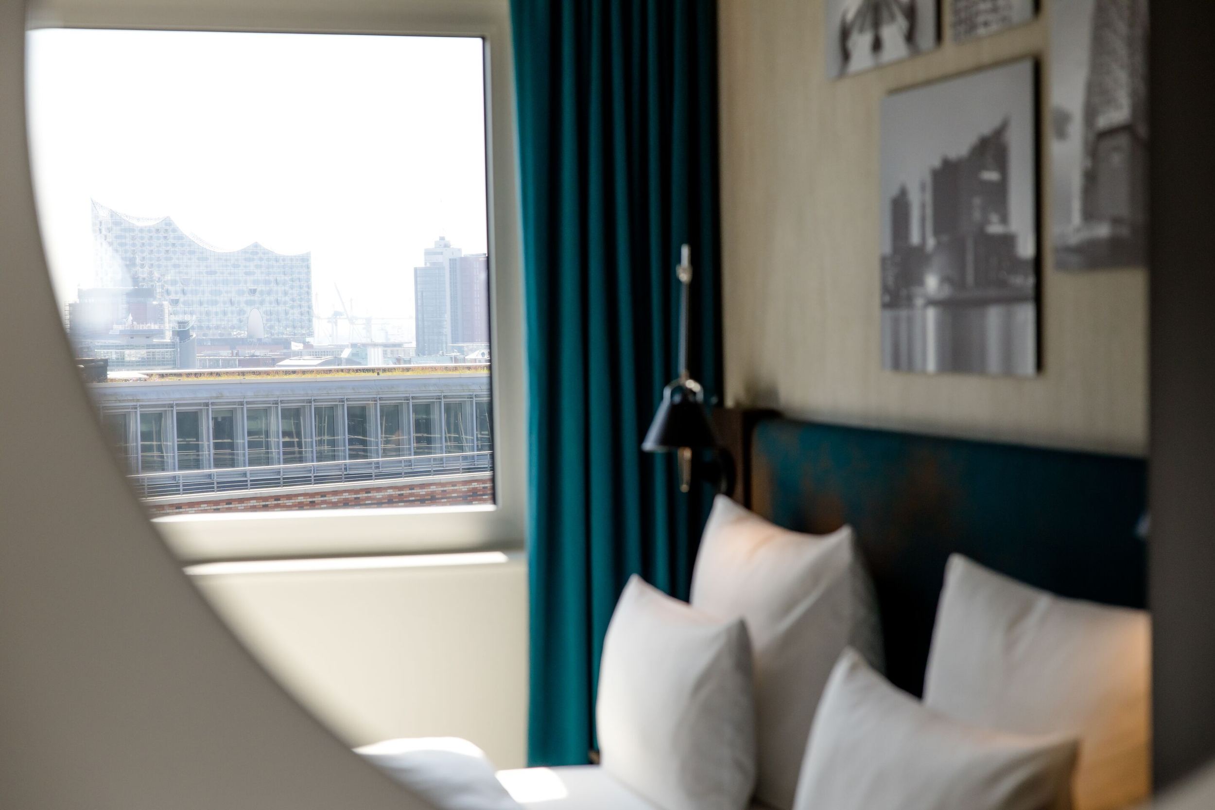 Hotel Hamburg am Michel Motel One Zimmer mit Blick auf ein Doppelbett sowie ein großes Fenster mit Aussicht auf die Stadt