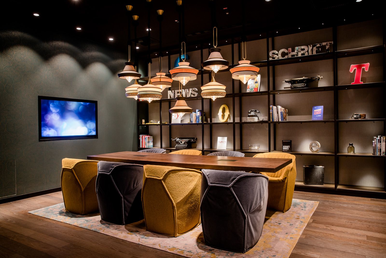 Hotel Hannover Oper Motel One Meetingraum mit Tisch und acht Stühlen sowie Fernseher an der Wand