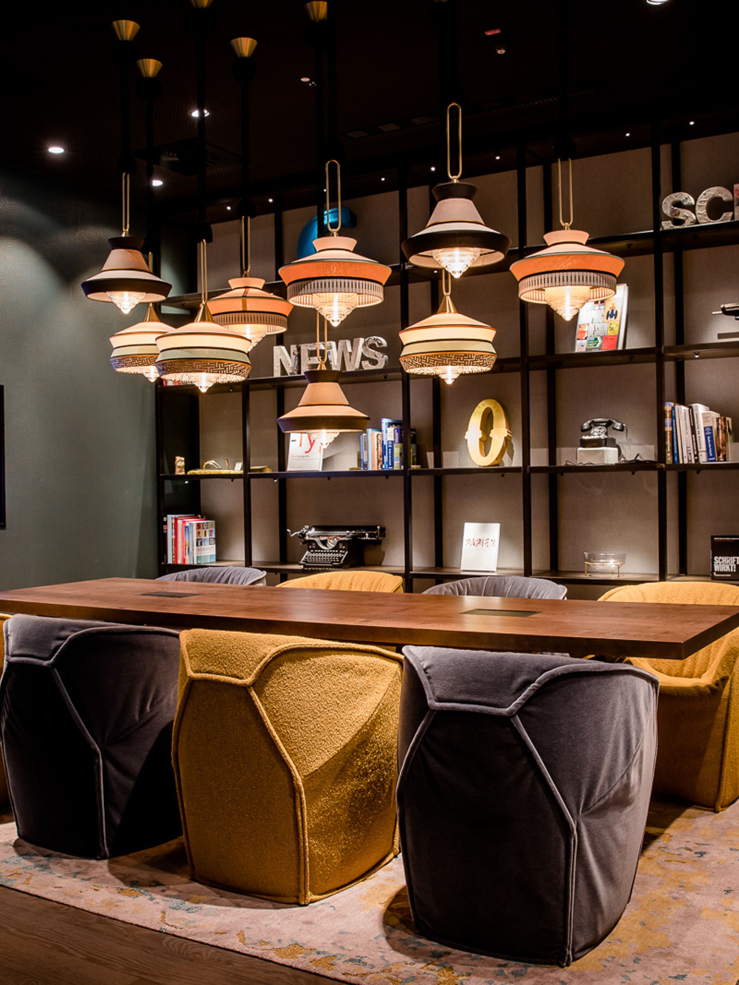 Hotel Hannover Oper Motel One Meetingraum mit Tisch und acht Stühlen sowie Fernseher an der Wand