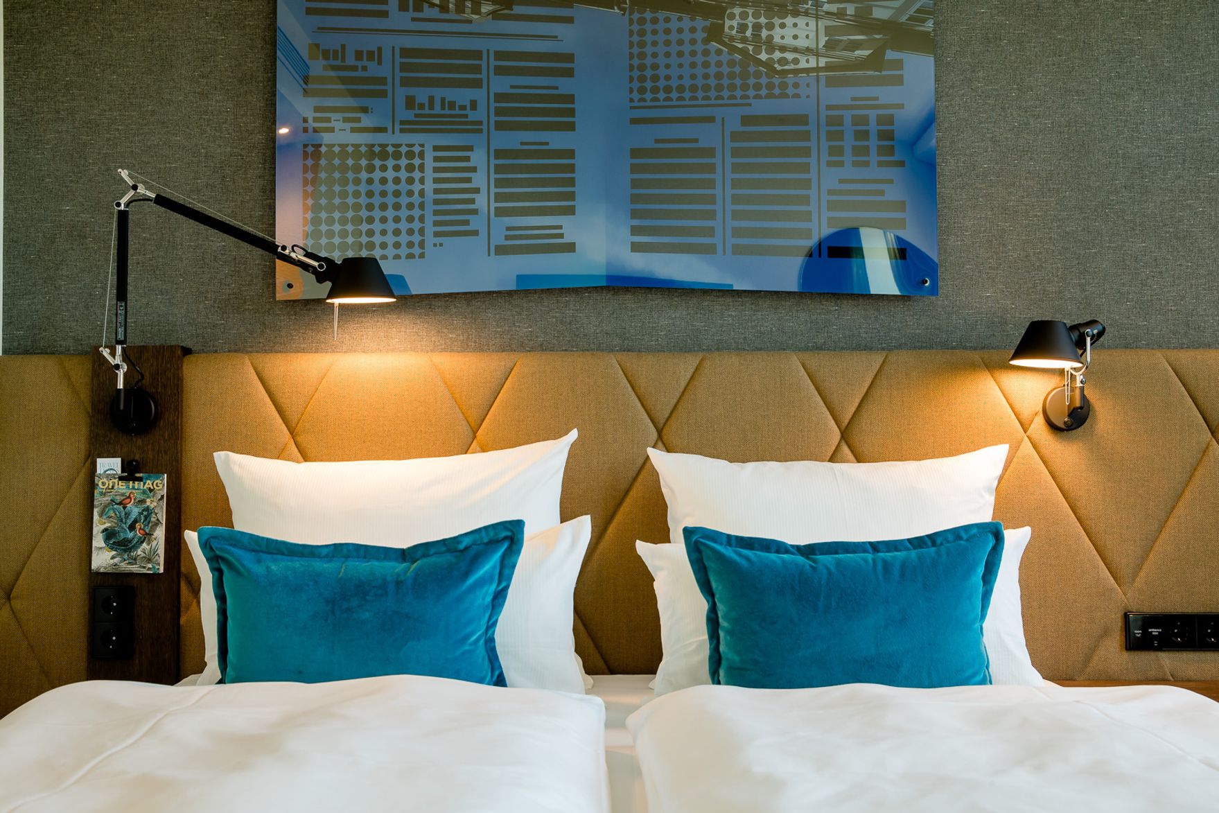 hotel Hanover Oper Motel One view of the headboard of a double bed with two decorative cushions in turquoise