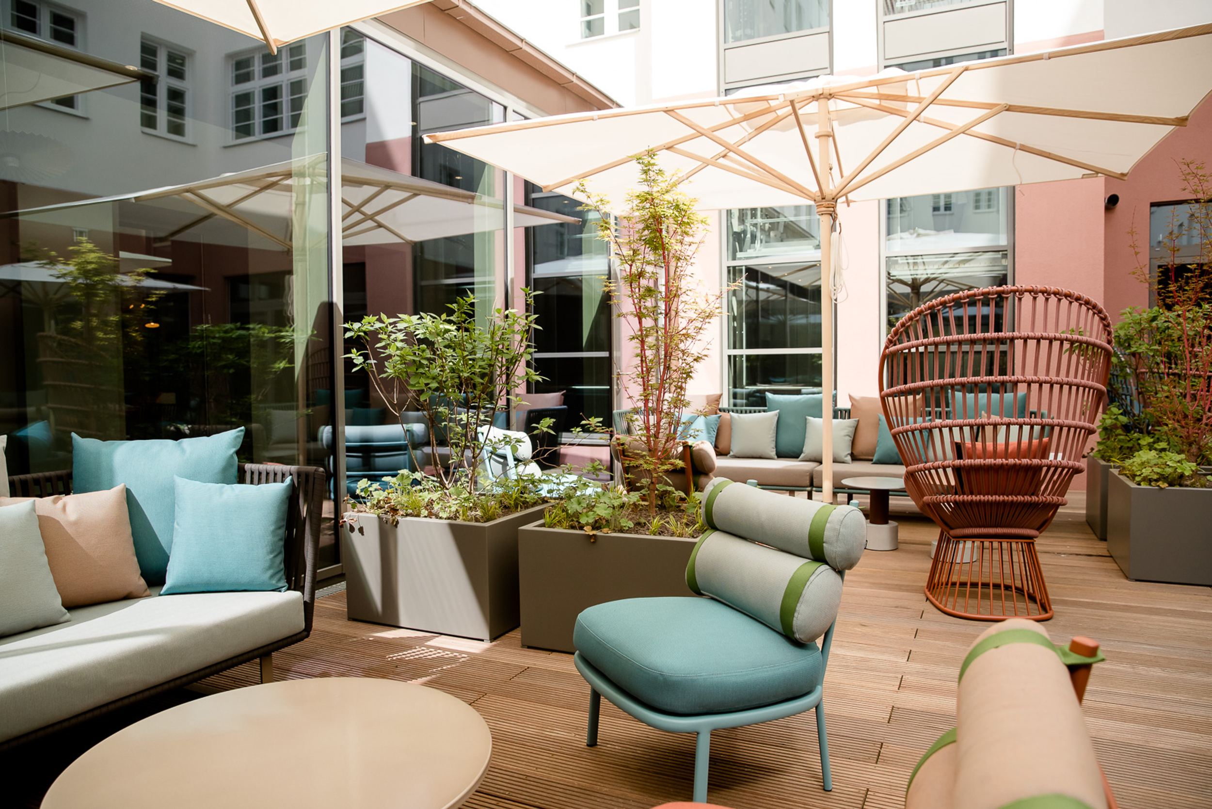 Hotel Hannover Oper Motel One helle Terrasse mit Sitzgelegenheiten und Sonnenschirmen