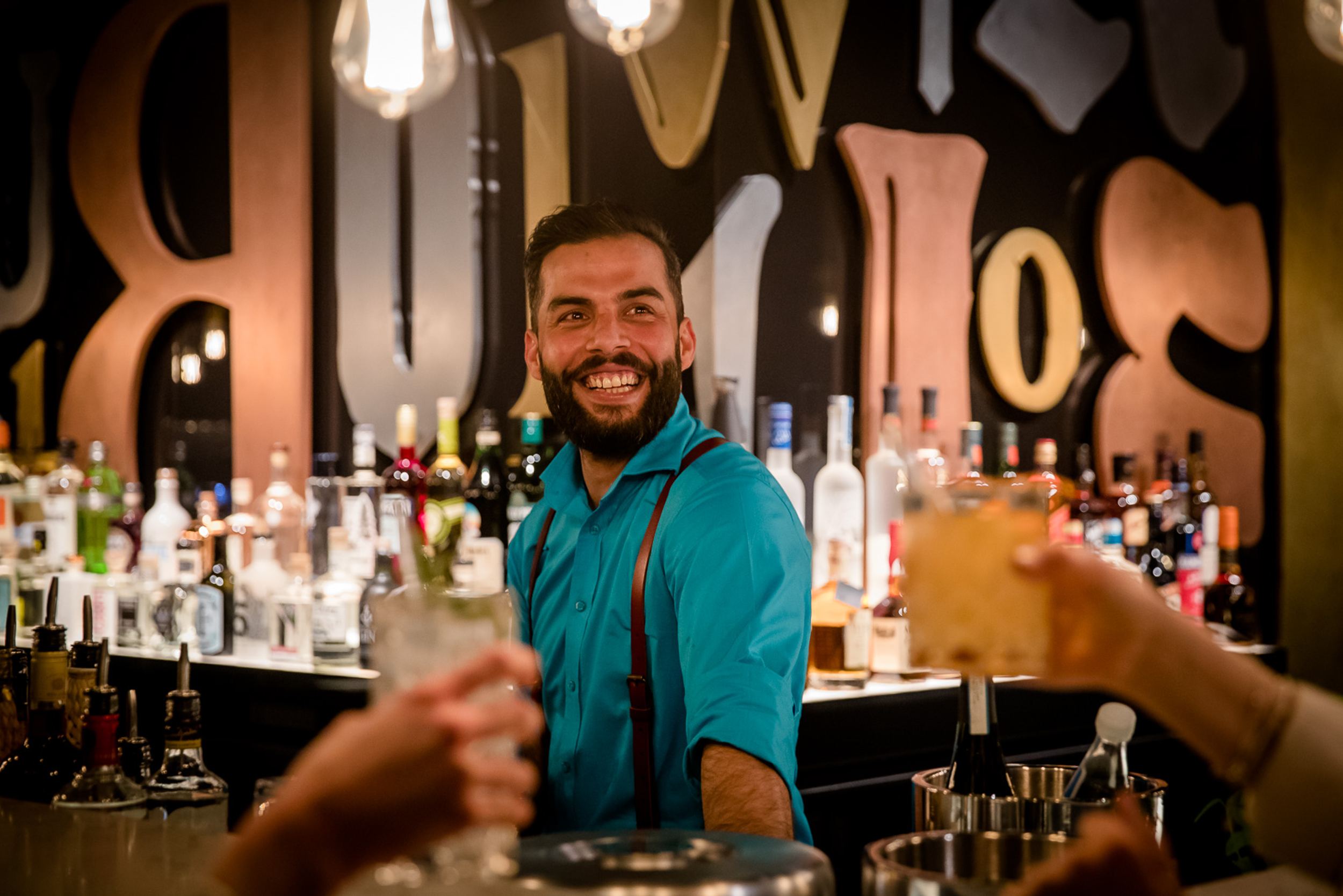 Designhotel Hannover Oper Motel One lächelnder Barkeeper hinter der Bar
