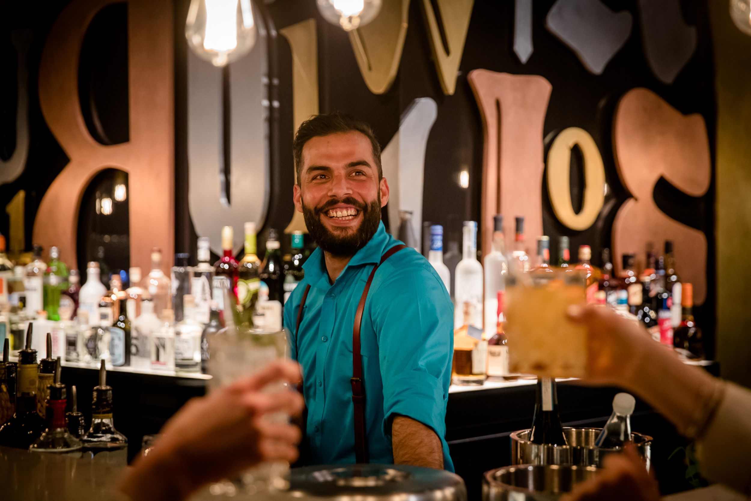 Designhotel Hannover Oper Motel One lächelnder Barkeeper hinter der Bar