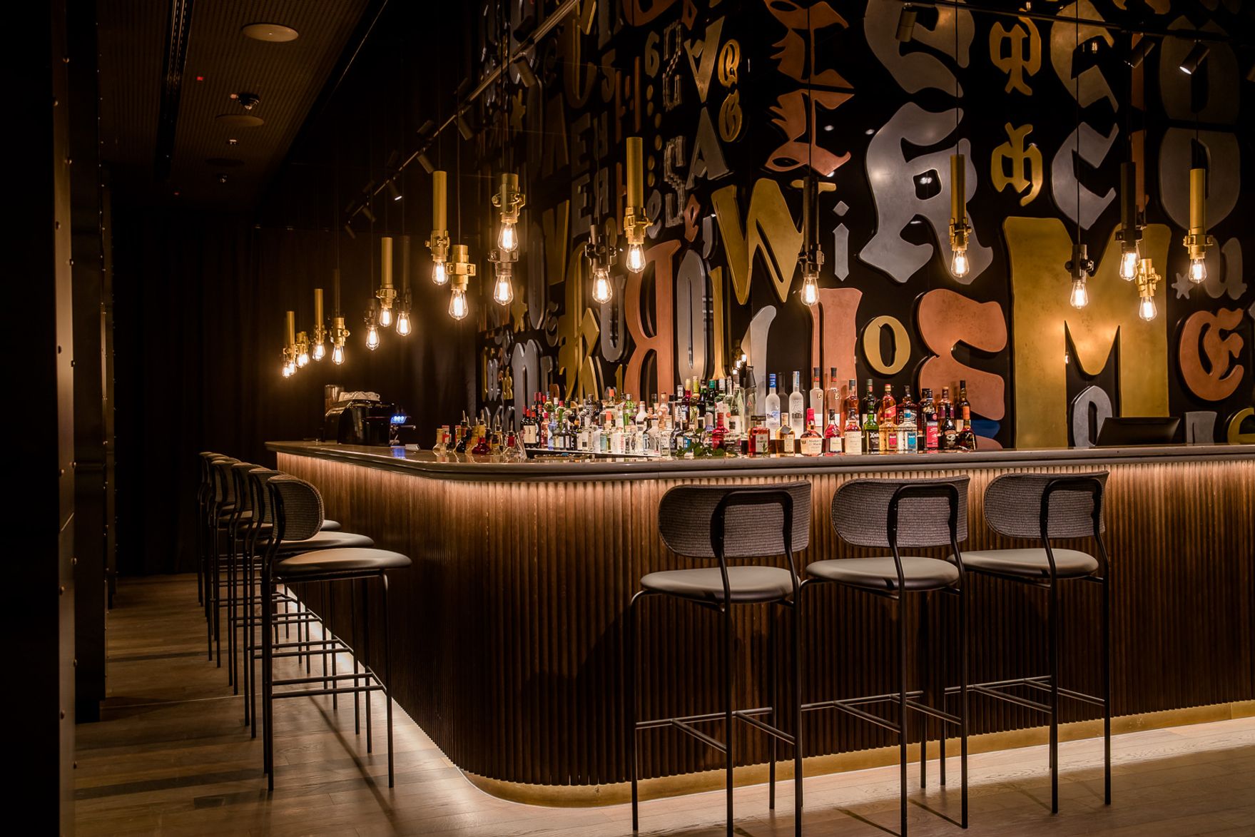 designhotel Hanover Oper Motel One bar with several bar stools at the counter