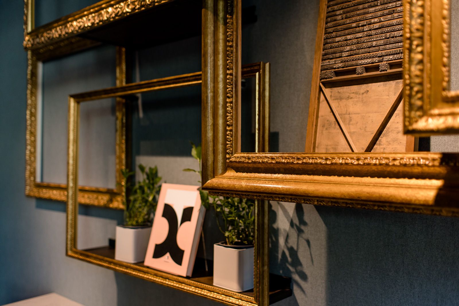 Designhotel Hannover Oper Motel One Nahaufnahme goldene Bilderrahmen mit Dekorationen an der Wand