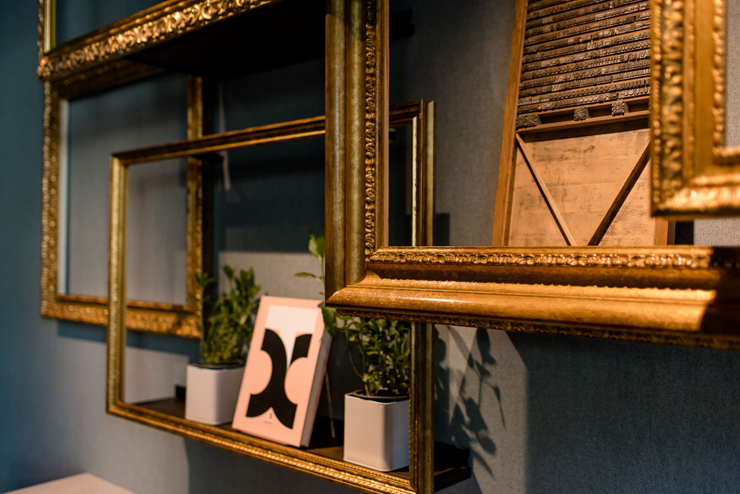 Designhotel Hannover Oper Motel One Nahaufnahme goldene Bilderrahmen mit Dekorationen an der Wand