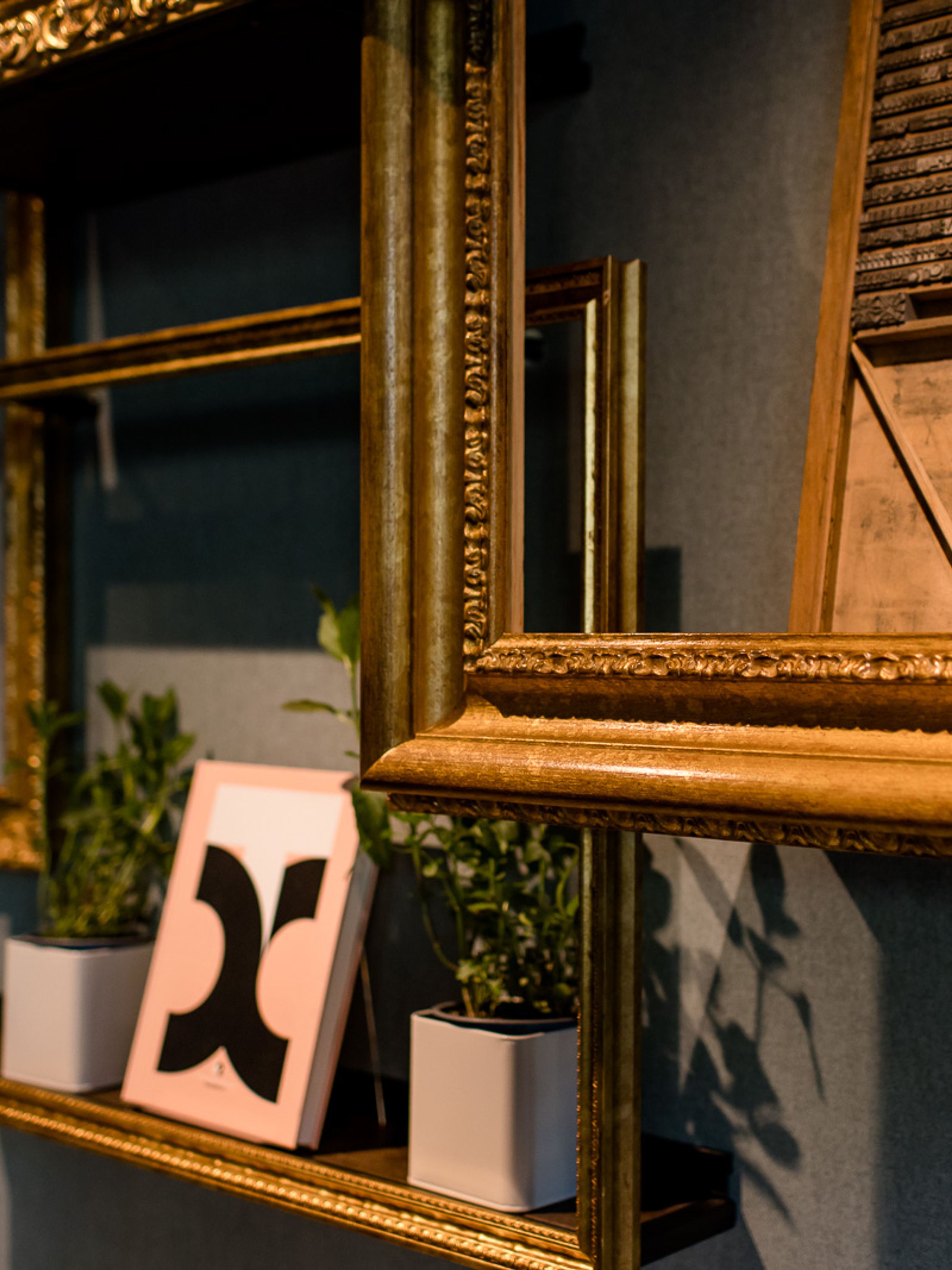 Designhotel Hannover Oper Motel One Nahaufnahme goldene Bilderrahmen mit Dekorationen an der Wand