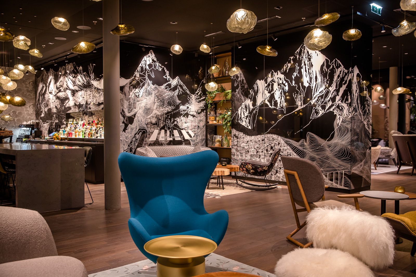 Designhotel Innsbruck Motel One Lounge am Abend mit Bar und Egg chair in der Mitte des Bildes