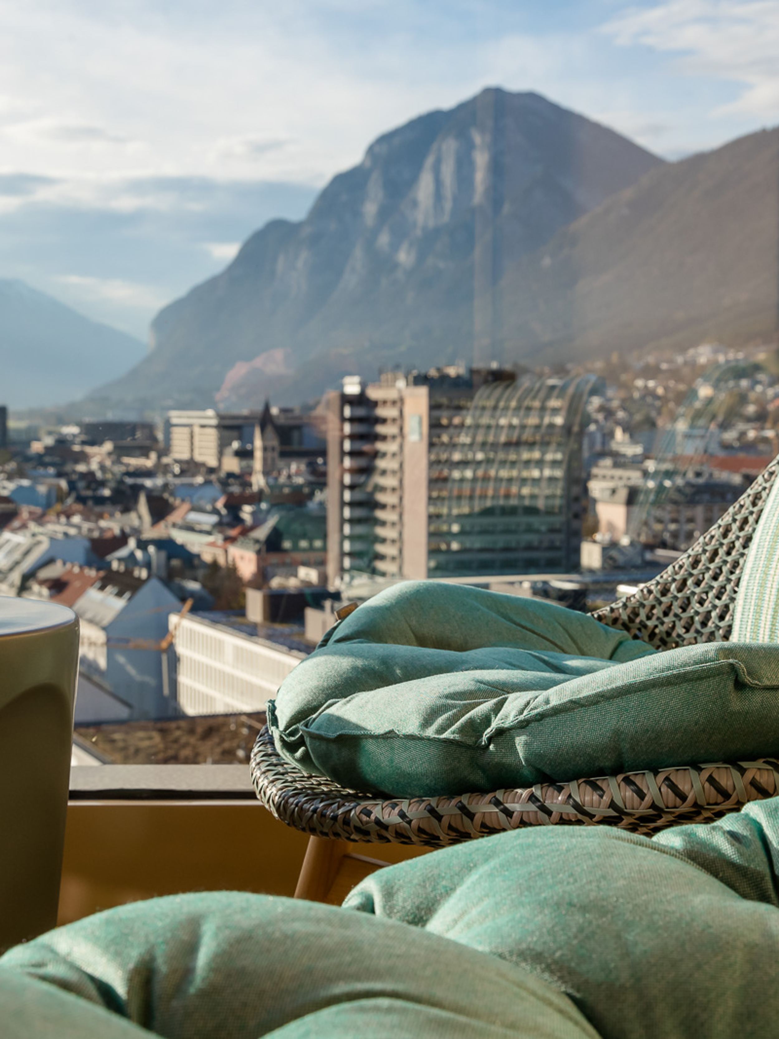 Designhotel Innsbruck Motel One Nahaufnahme Sessel vor bodentiefem Fenster mit toller Aussicht