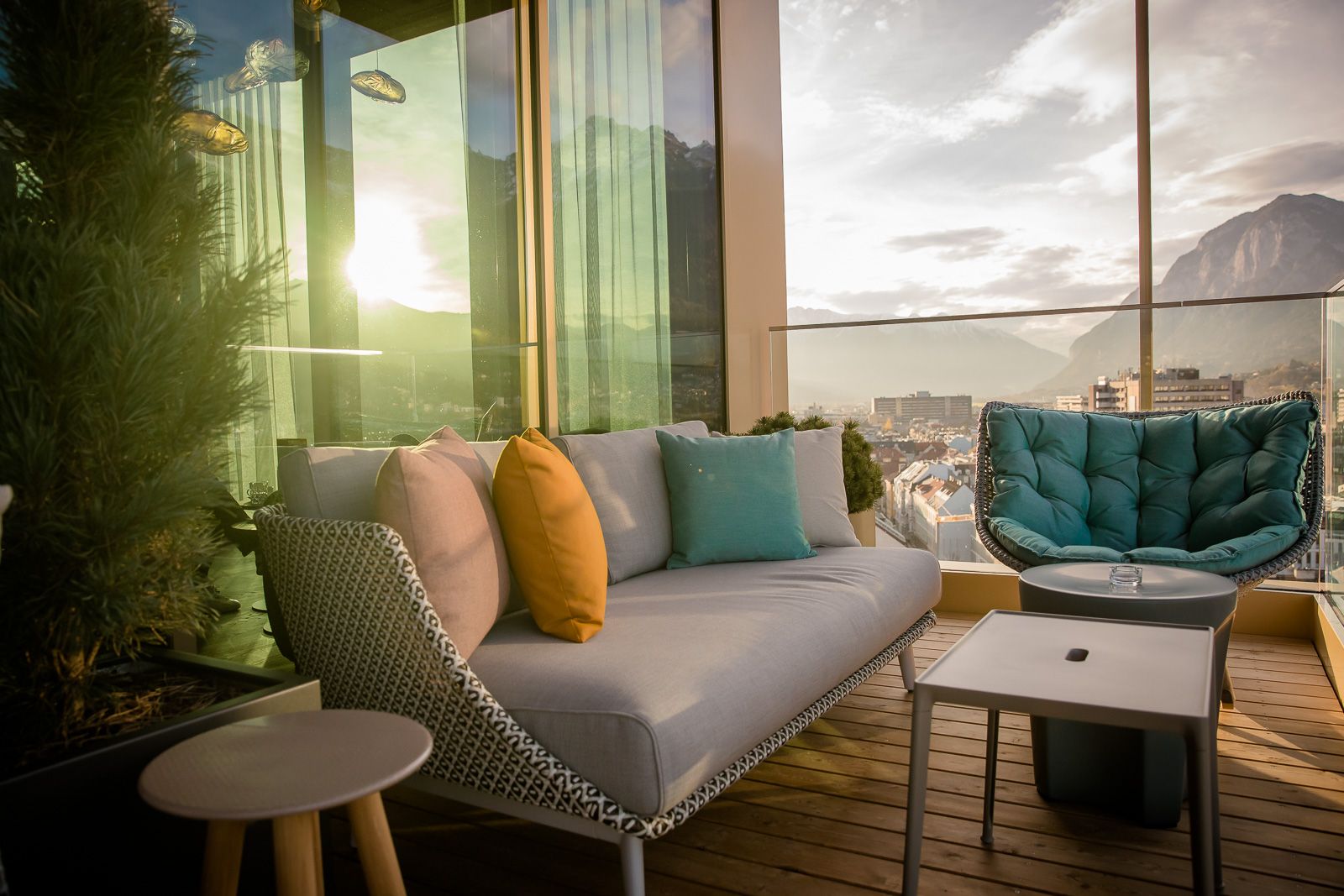 Designhotel Innsbruck Motel One Sitzgruppe auf Rooftop Terrasse mit Ausblick über die Stadt und auf die Alpen