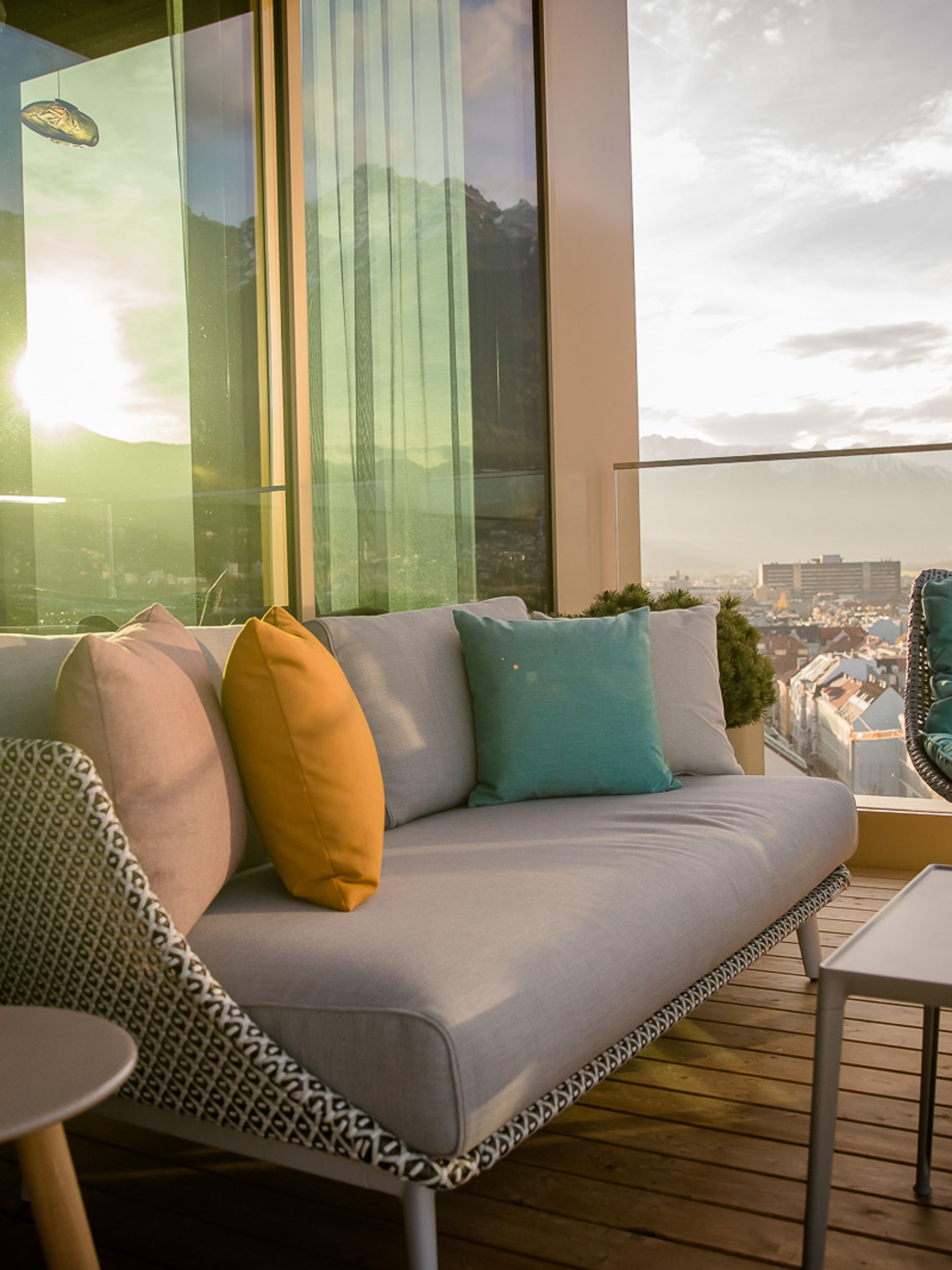 Designhotel Innsbruck Motel One Sitzgruppe auf Rooftop Terrasse mit Ausblick über die Stadt und auf die Alpen