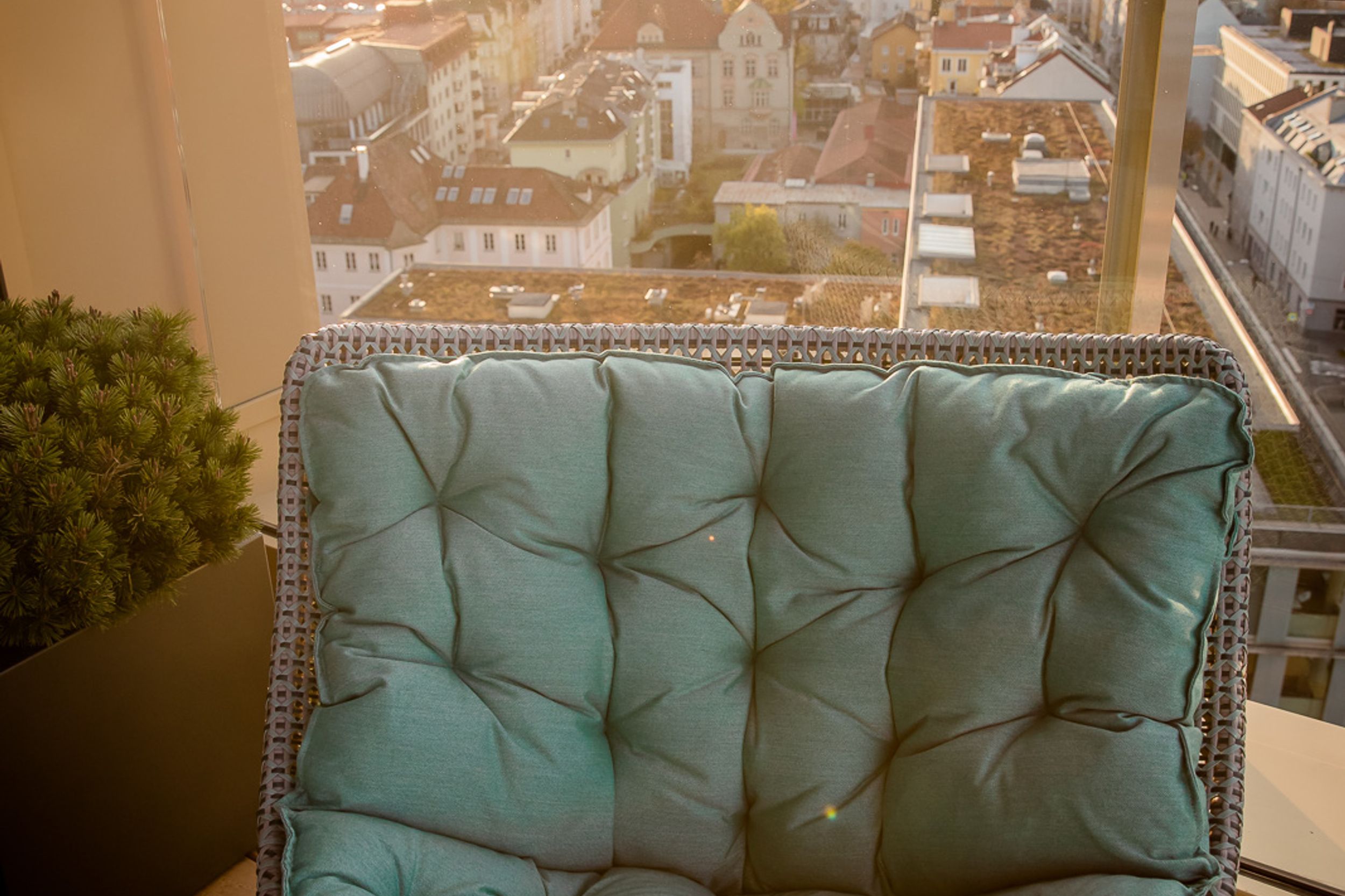 Designhotel Innsbruck Motel One Sessel vor bodentiefem Fenster mit Blick auf Berge und Stadt