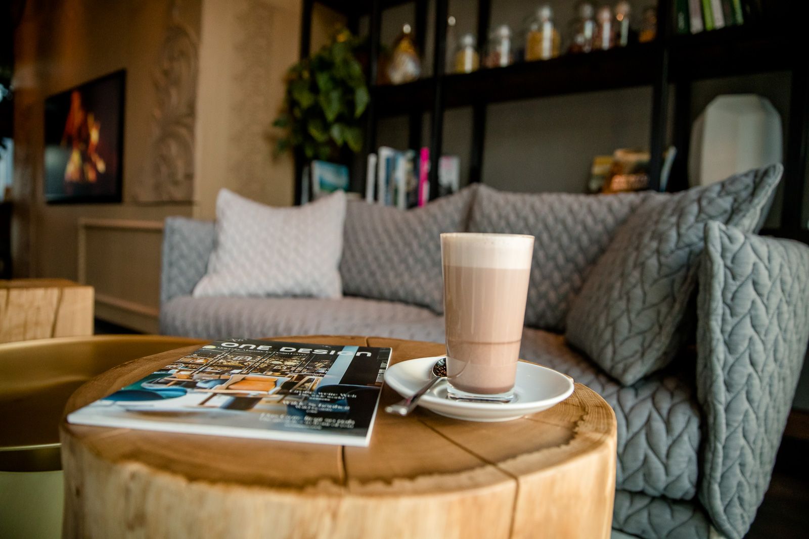 Designhotel Innsbruck Motel One Nahaufnahme Tisch mit Couch und Latte Macchiato