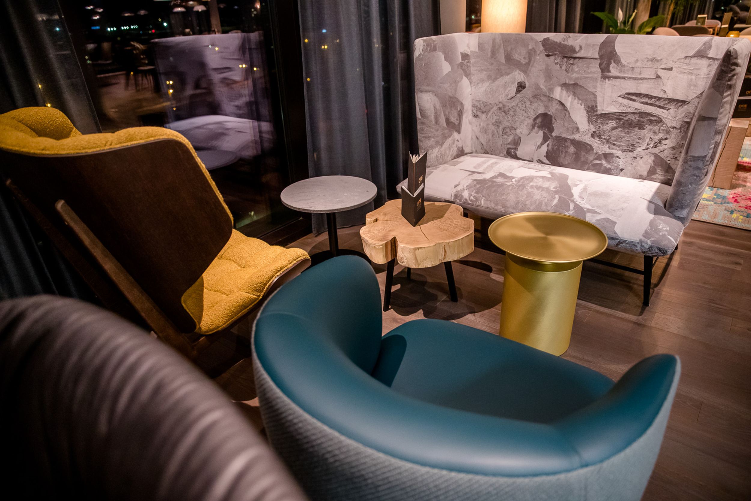 Hotel Innsbruck Motel One Sessel mit Beistelltischen in der Lounge bei Abend