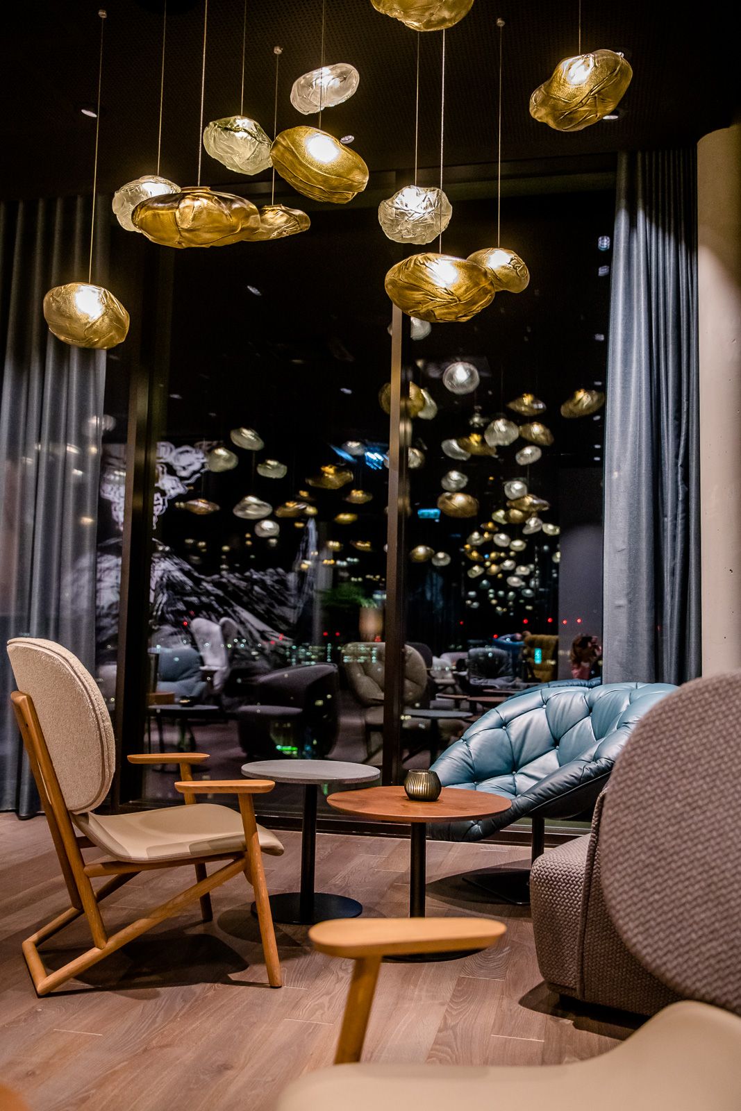 Hotel Innsbruck Motel One Lounge bei Abend mit Sesseln und Beleuchtung für eine gemütliche Atmosphäre