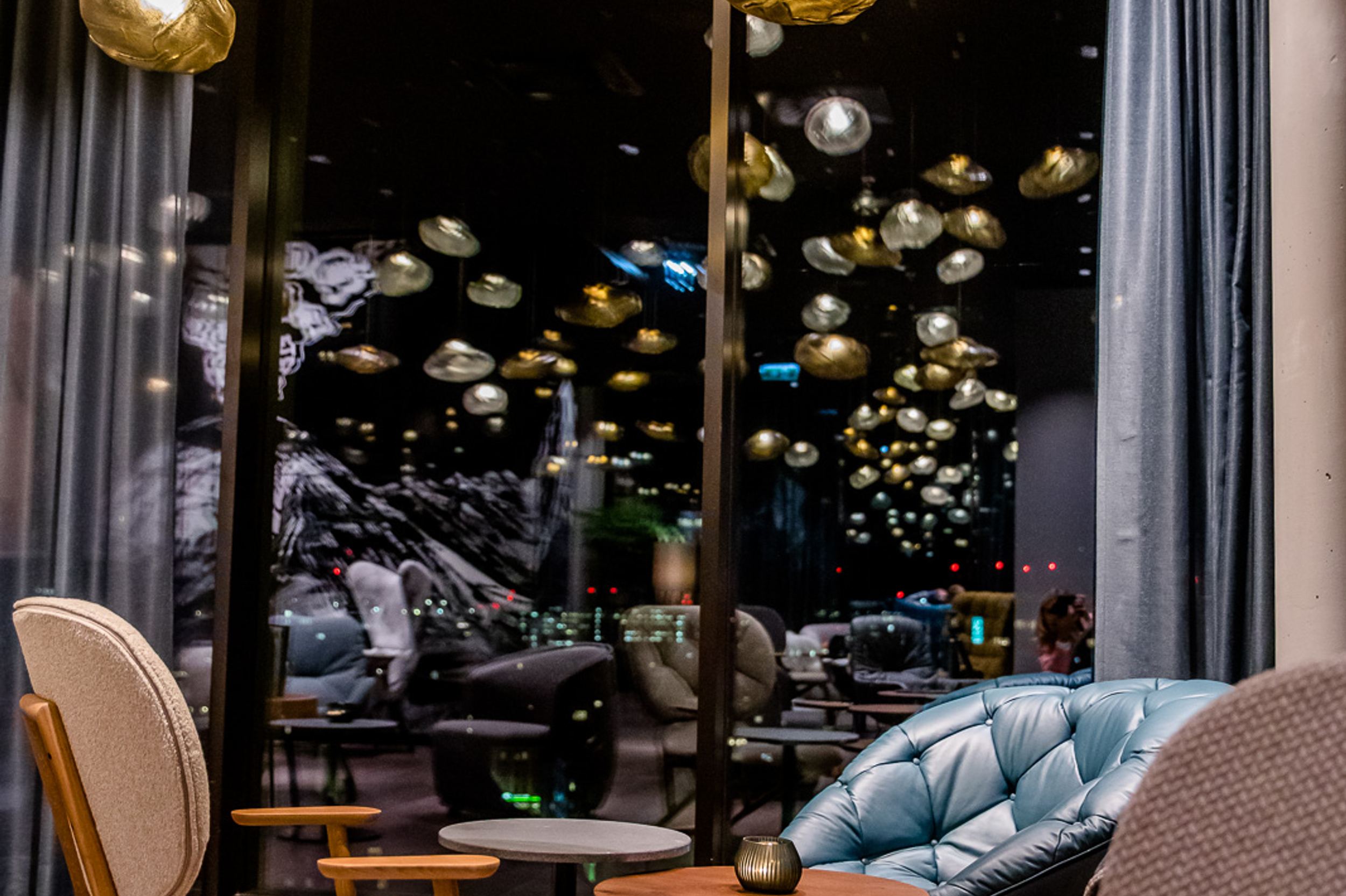 Hotel Innsbruck Motel One Lounge bei Abend mit Sesseln und Beleuchtung für eine gemütliche Atmosphäre