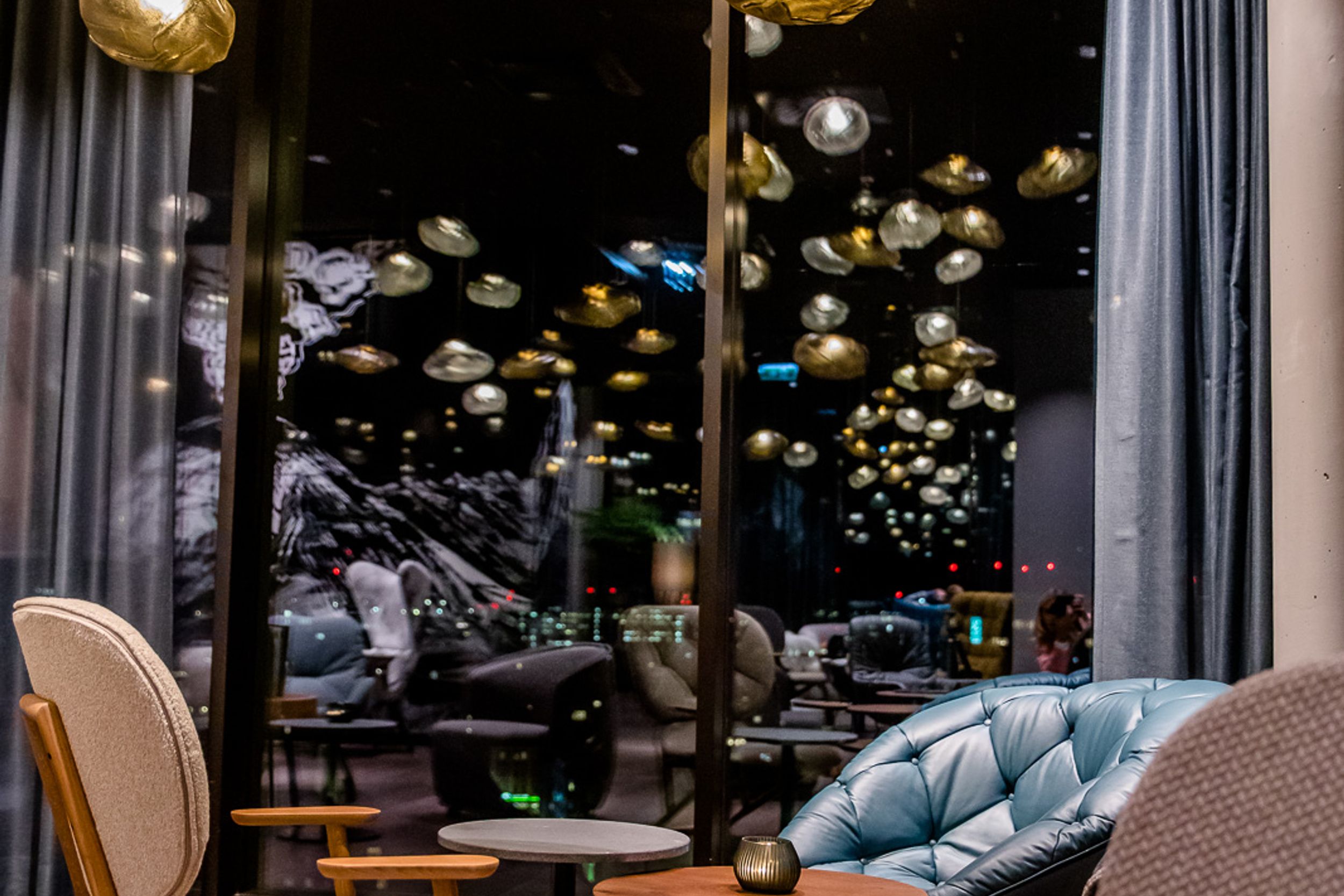 Hotel Innsbruck Motel One Lounge bei Abend mit Sesseln und Beleuchtung für eine gemütliche Atmosphäre