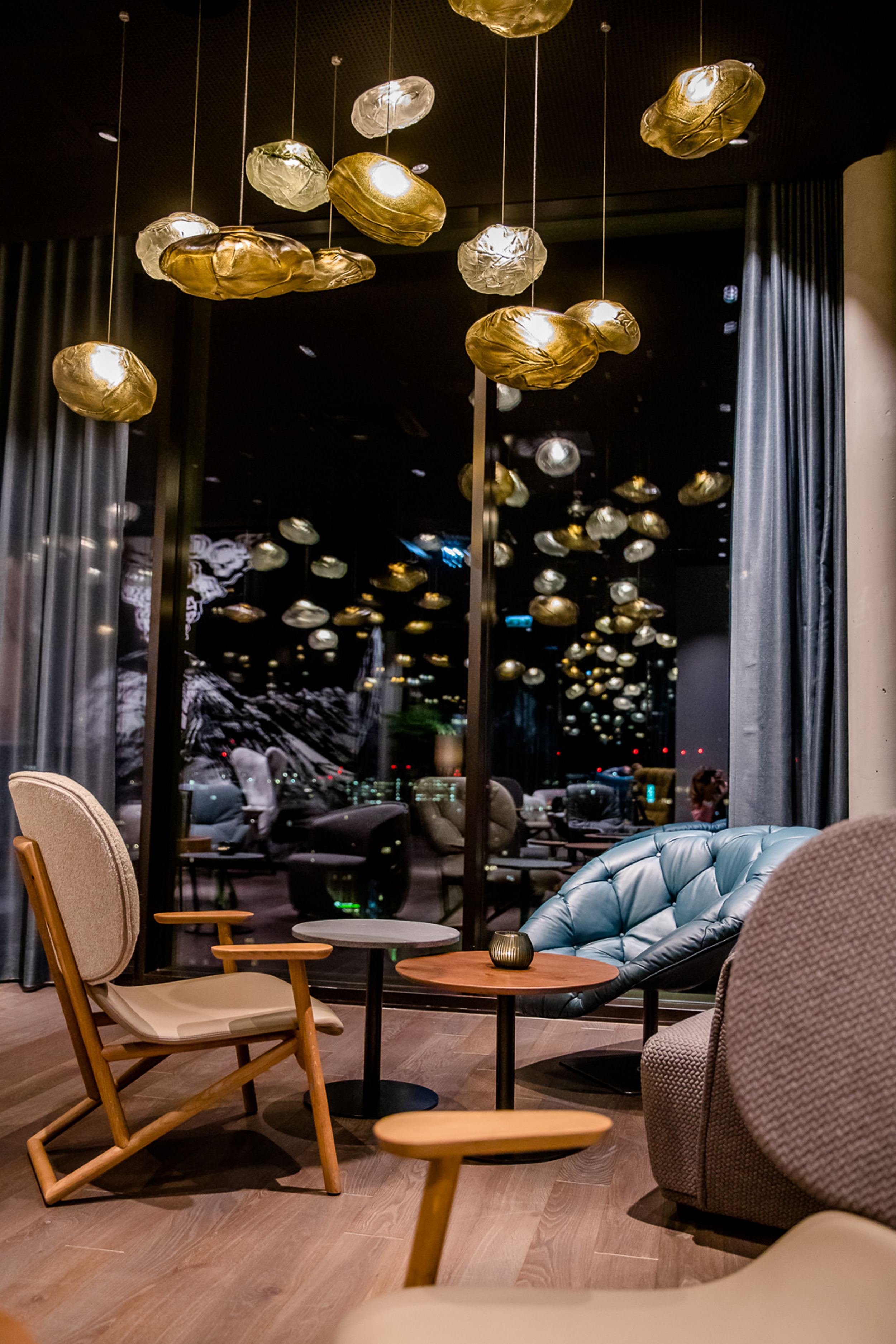 Hotel Innsbruck Motel One Lounge bei Abend mit Sesseln und Beleuchtung für eine gemütliche Atmosphäre