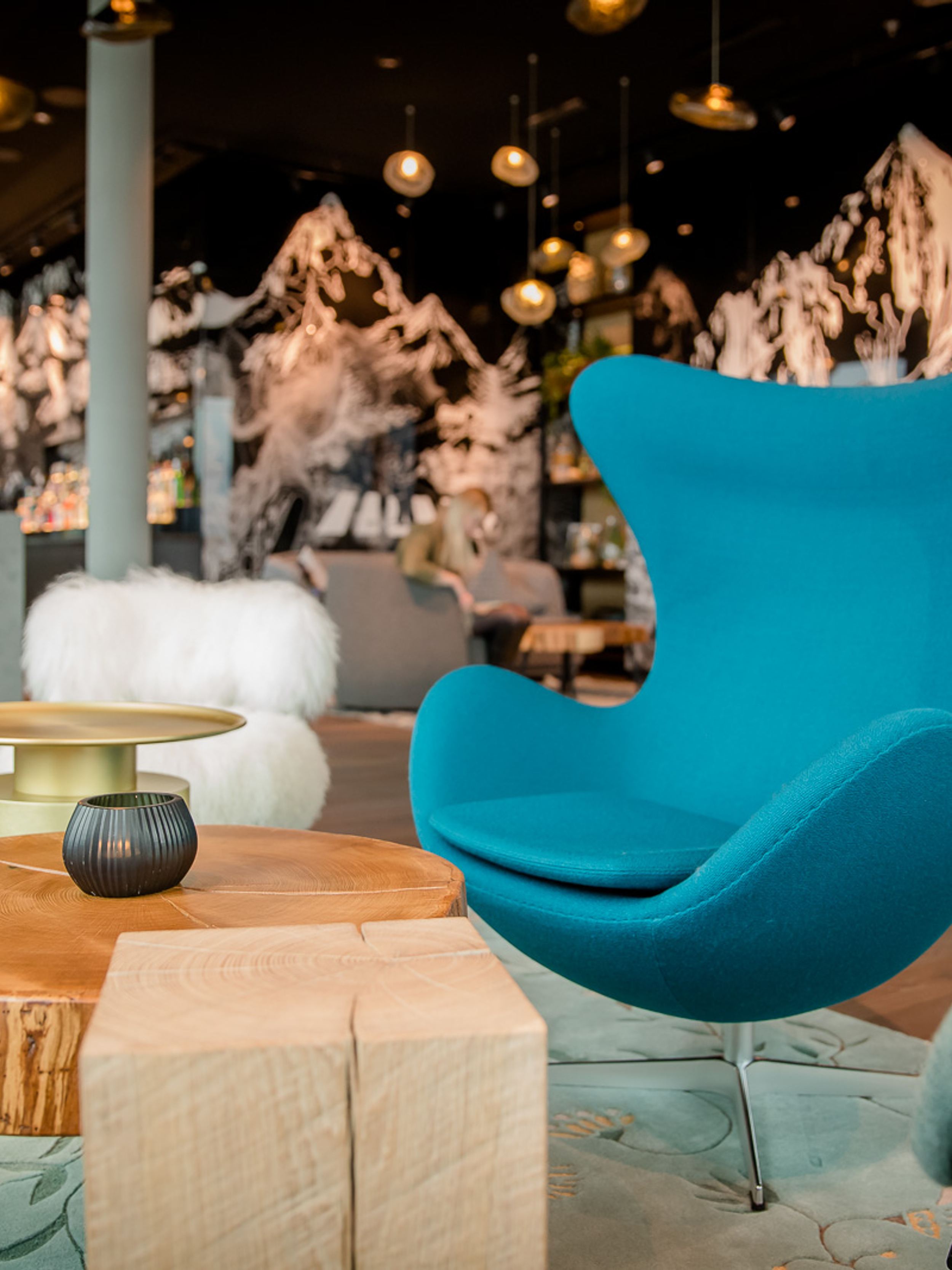 Hotel Innsbruck Motel One Egg chair in Lounge sowie Bar im Hintergrund