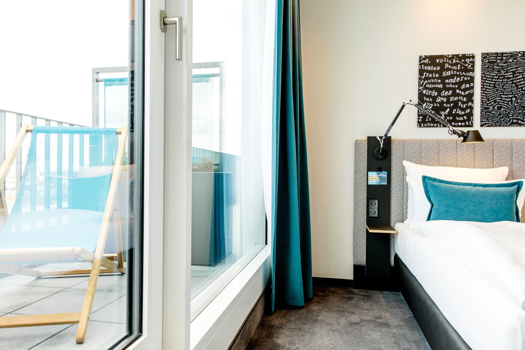 Hotel Karlsruhe Motel One Zimmer mit bodentiefem Fenster und Balkonzugang mit Liegestuhl