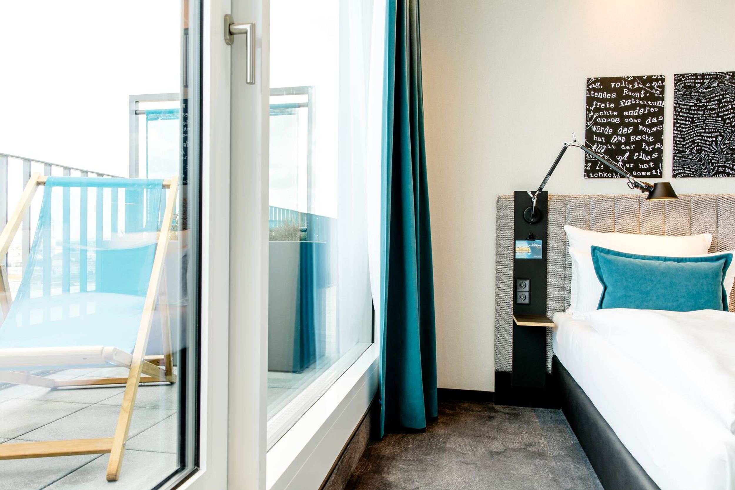 Hotel Karlsruhe Motel One Zimmer mit bodentiefem Fenster und Balkonzugang mit Liegestuhl