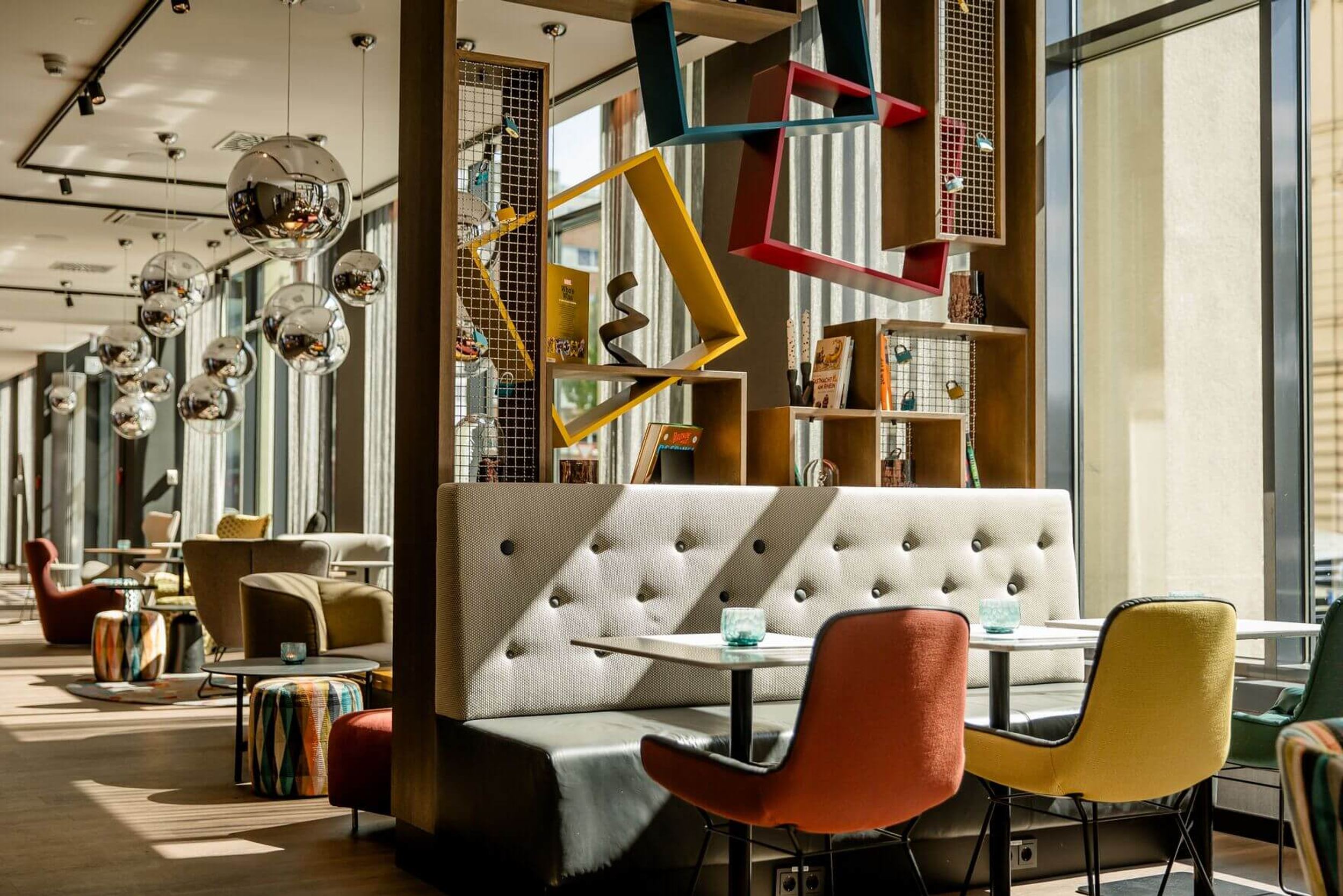 Hotel Köln Mediapark Motel One lichtdurchfluteter Frühstücksbereich mit mehreren Sitzgelegenheiten