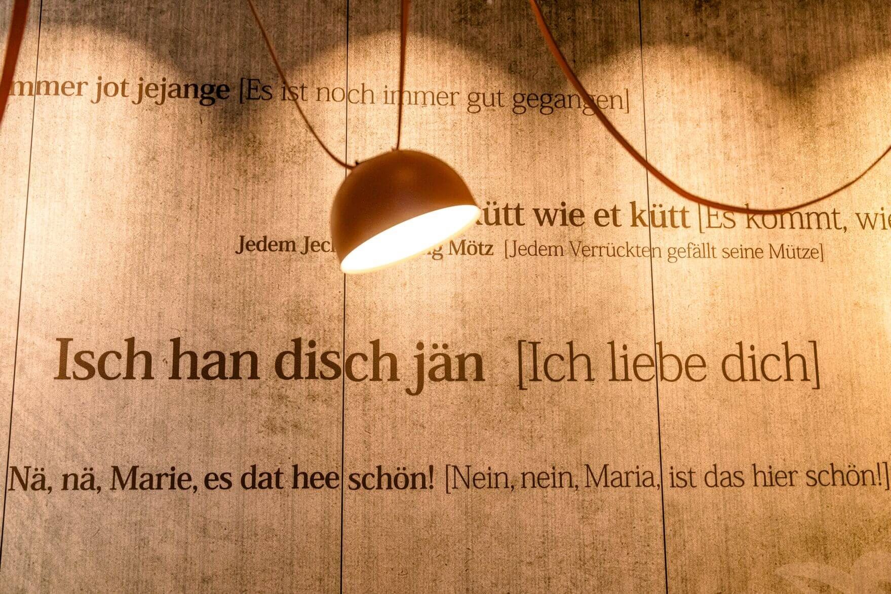designhotel Cologne Mediapark Motel One wall with sentences and a lamp in the foreground