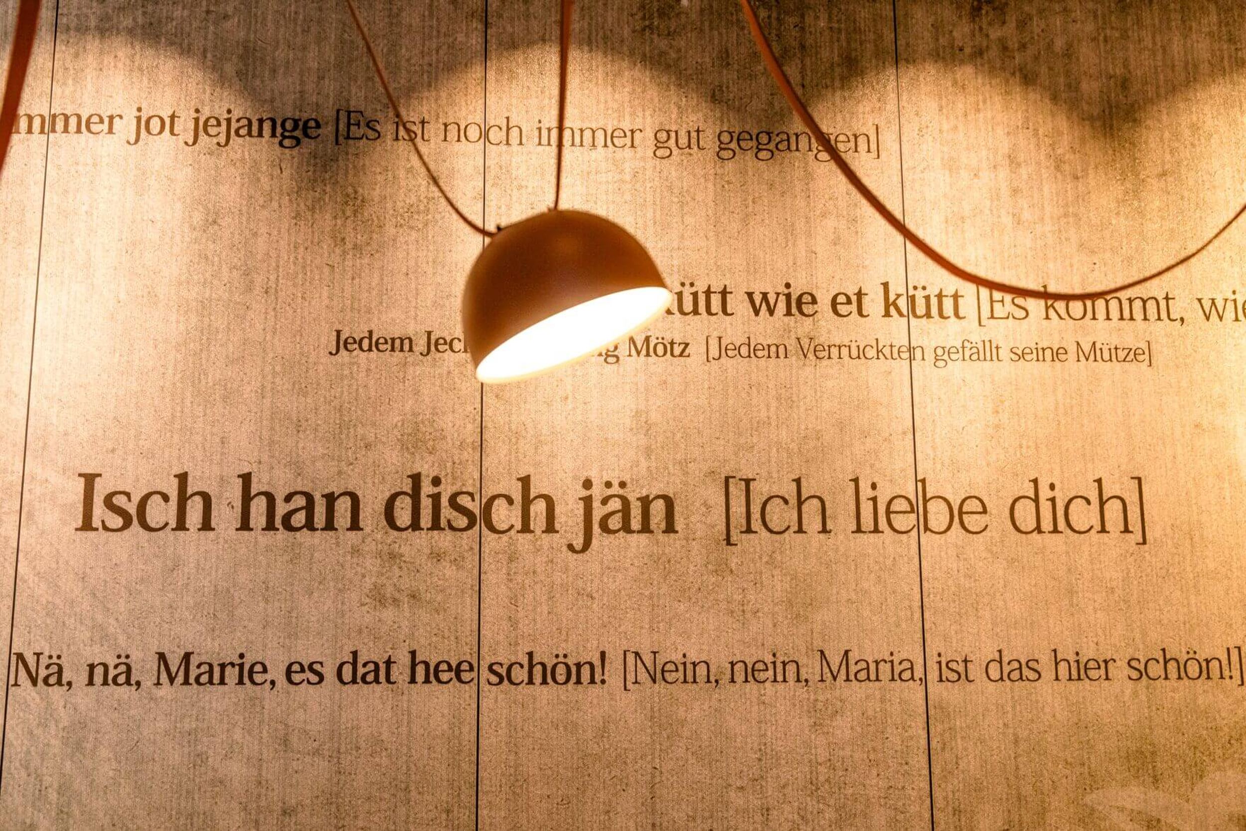 Designhotel Köln Mediapark Motel One Wand mit Sätzen und einer Lampe im Vordergrund