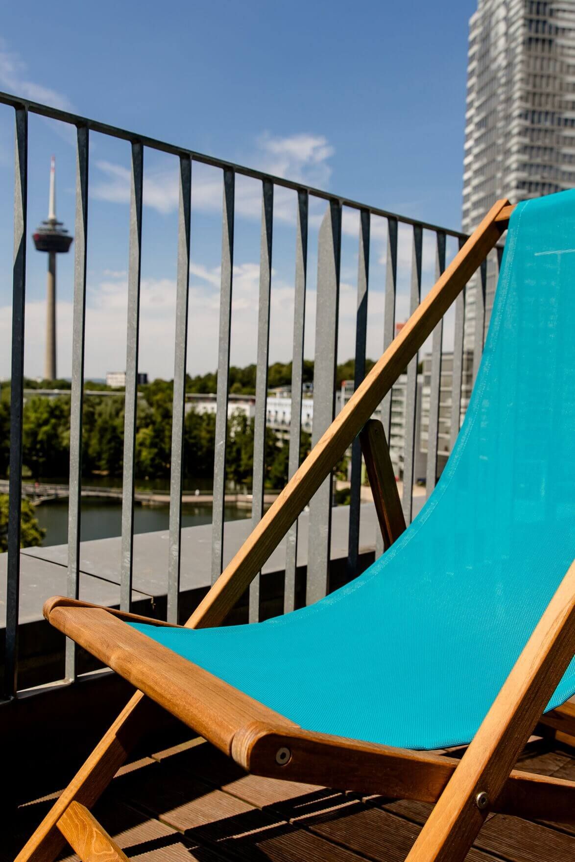 Hotel Köln Mediapark Motel One Liegestuhl auf einem Balkon mit Aussicht über die Stadt