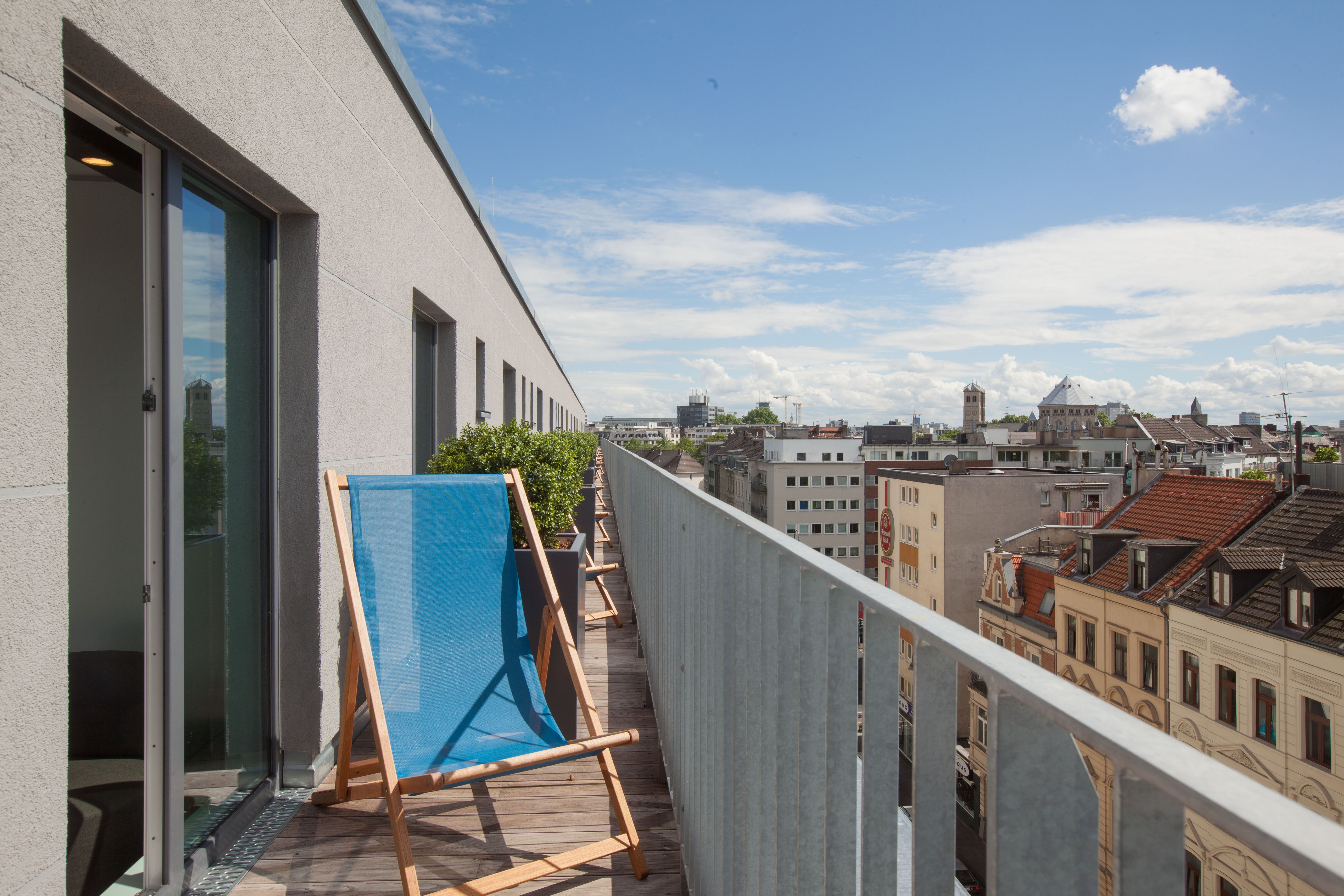 Designhotel Köln Mediapark Motel One Balkonzimmer mit Liegestuhl und Aussicht über die Stadt