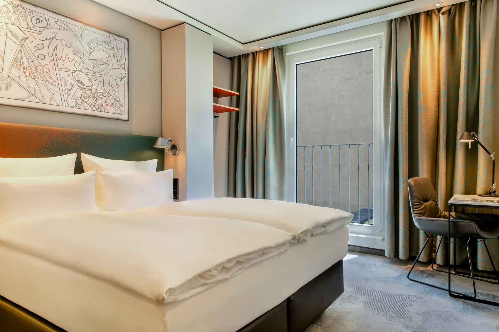 Designhotel Köln Mediapark Motel One lichtdurchflutetes Zimmer mit Doppelbett sowie Schreibtisch mit Stuhl