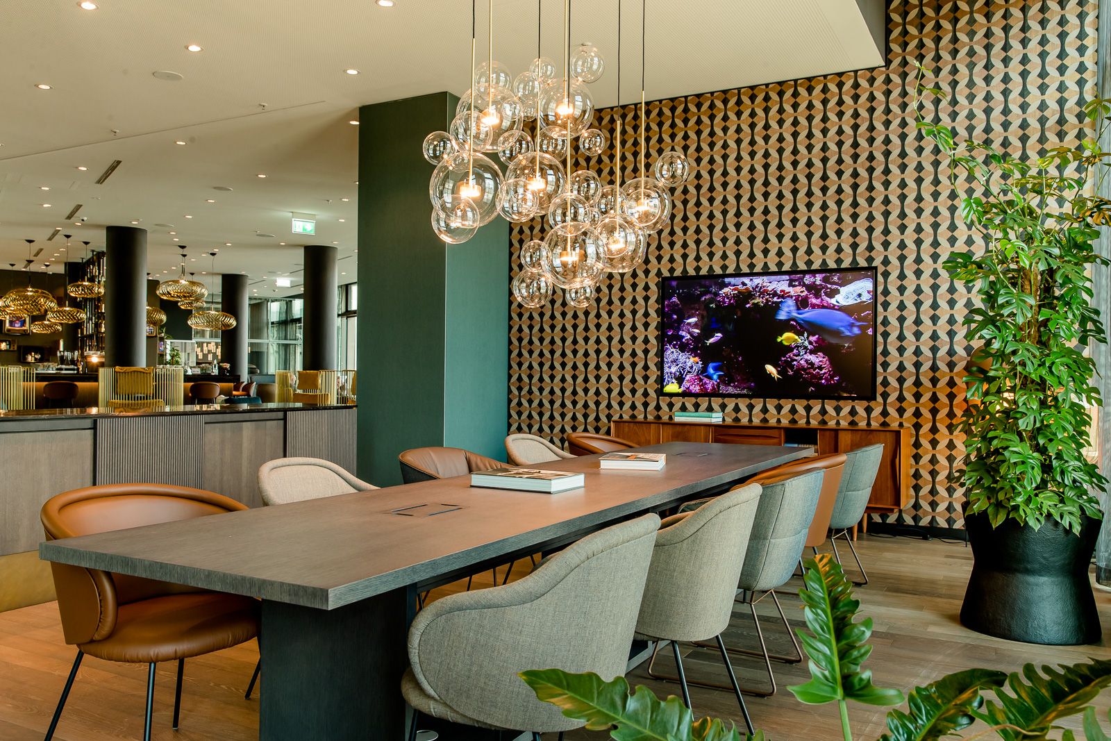 Hotel Köln Messe Motel One langer Tisch mit zehn Stühlen sowie Fernseher an der Wand