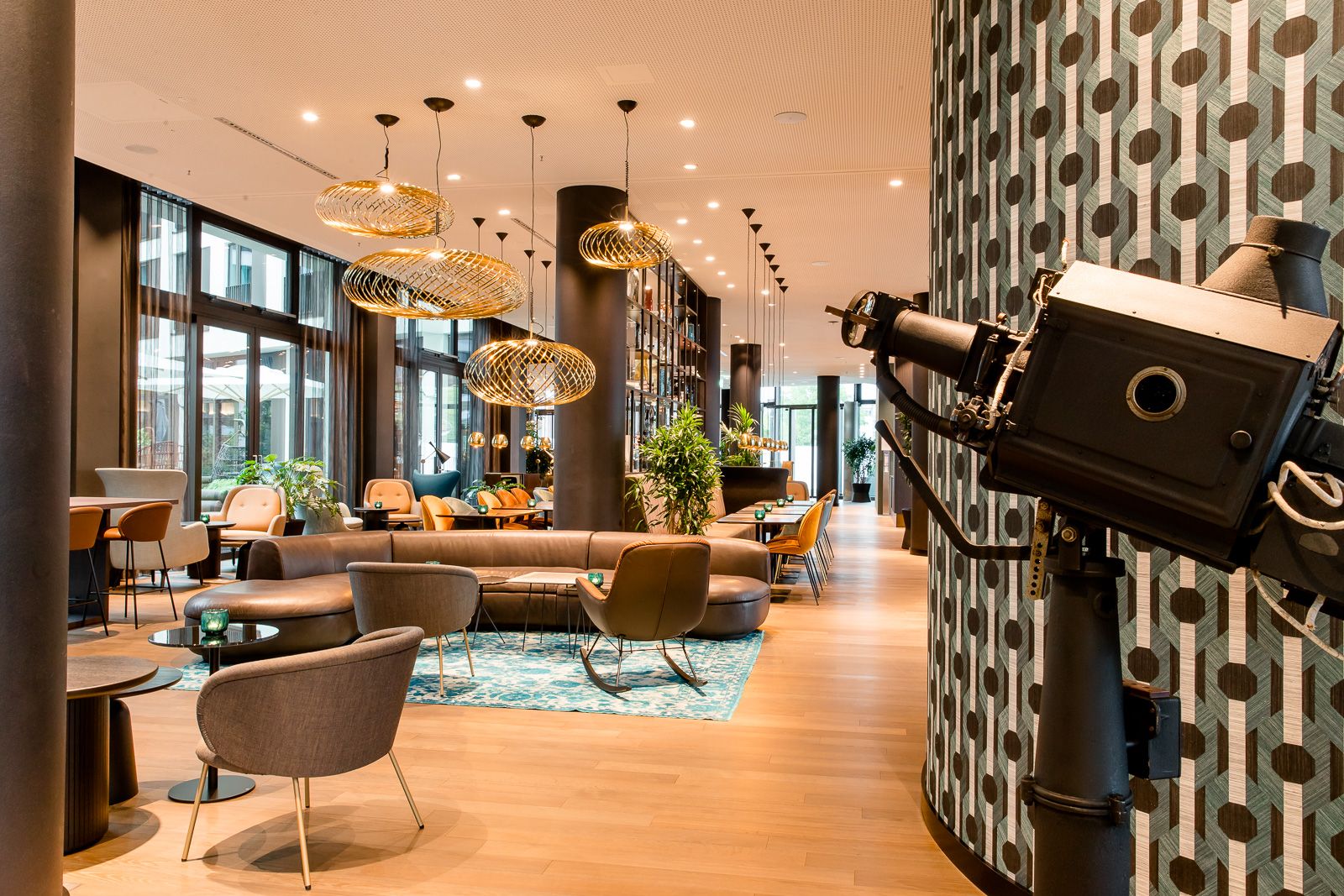 Hotel Köln Messe Motel One lichtdurchflutete Lounge mit mehreren Sesseln und Tischen