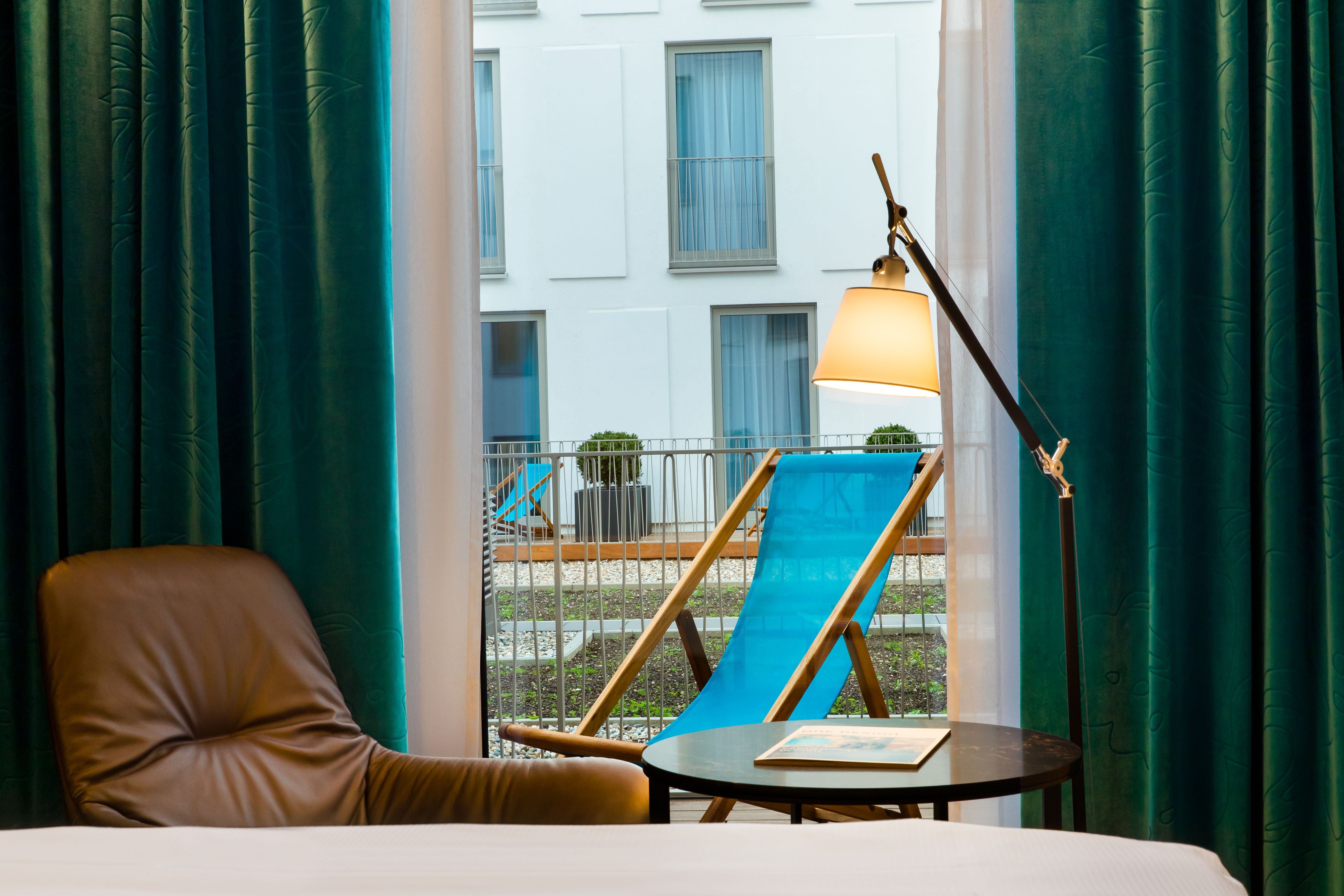 designhotel Cologne Neumarkt Motel One room with a view over an armchair to a deckchair in turquoise