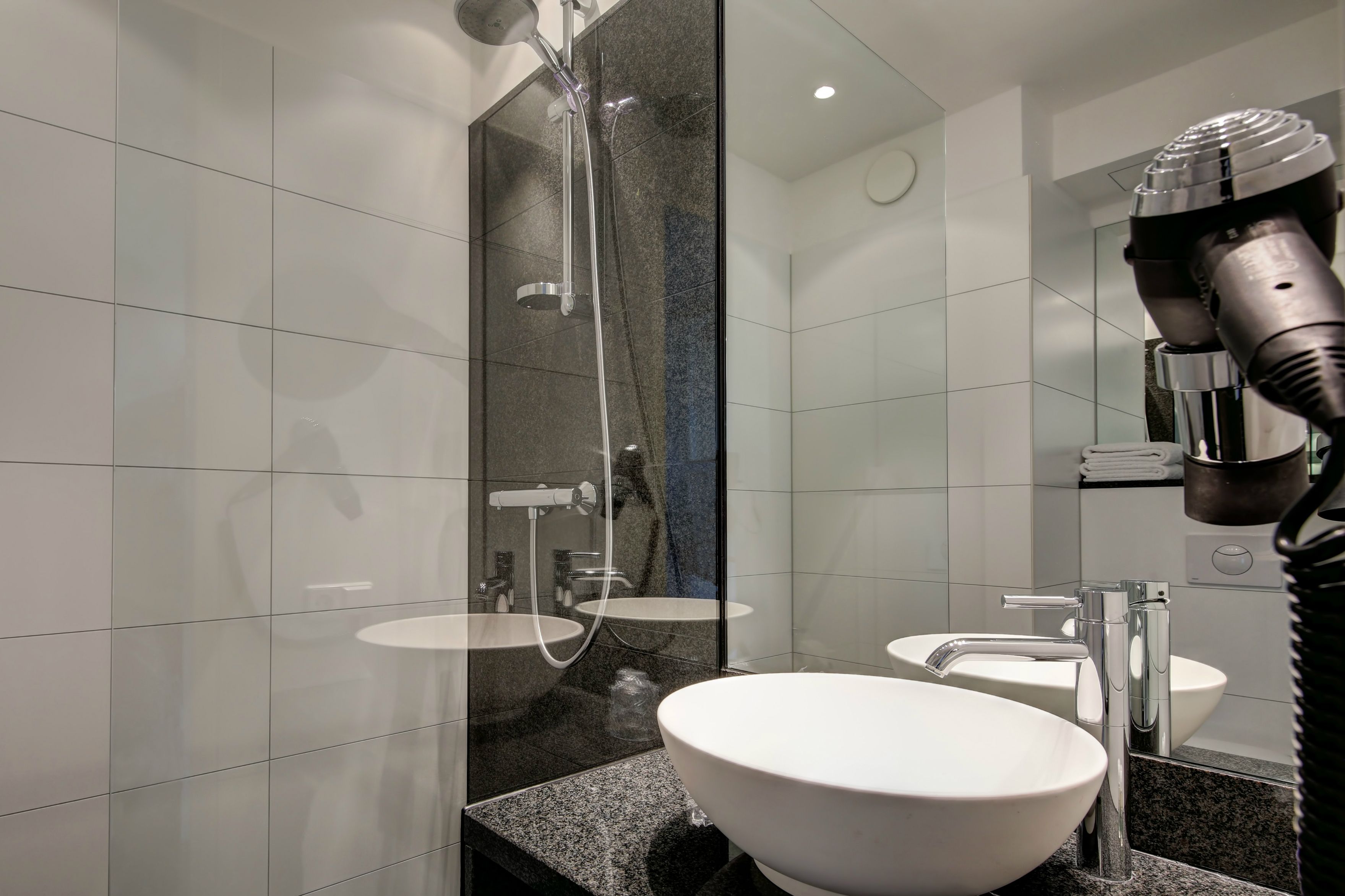 Hotel Köln Neumarkt Motel One Bad mit Dusche, Waschbecken sowie großem Spiegel