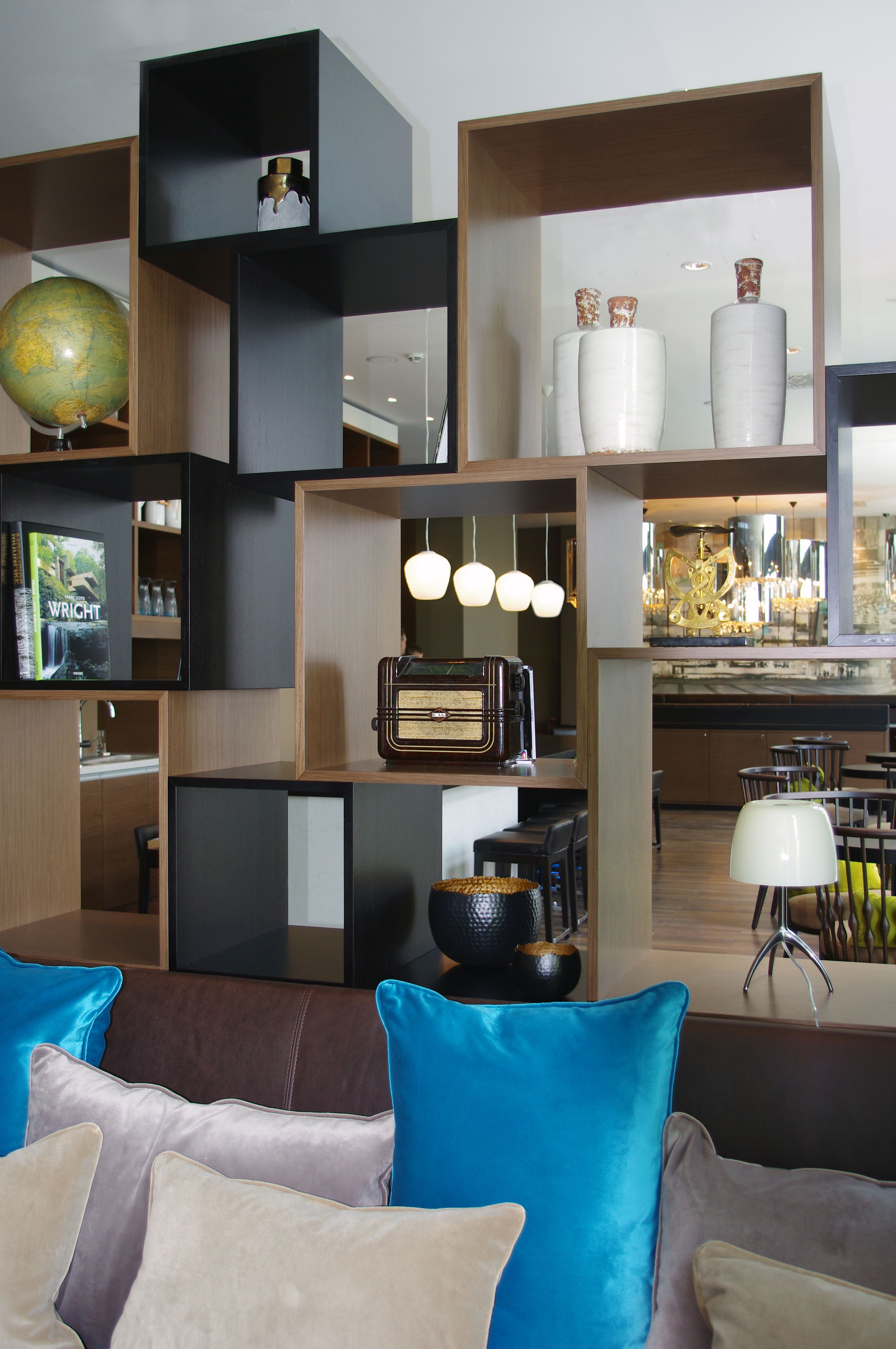 Hotel Leipzig Augustusplatz Motel One helle Lounge mit offenem Regal sowie Couch und Sitzgelegenheiten