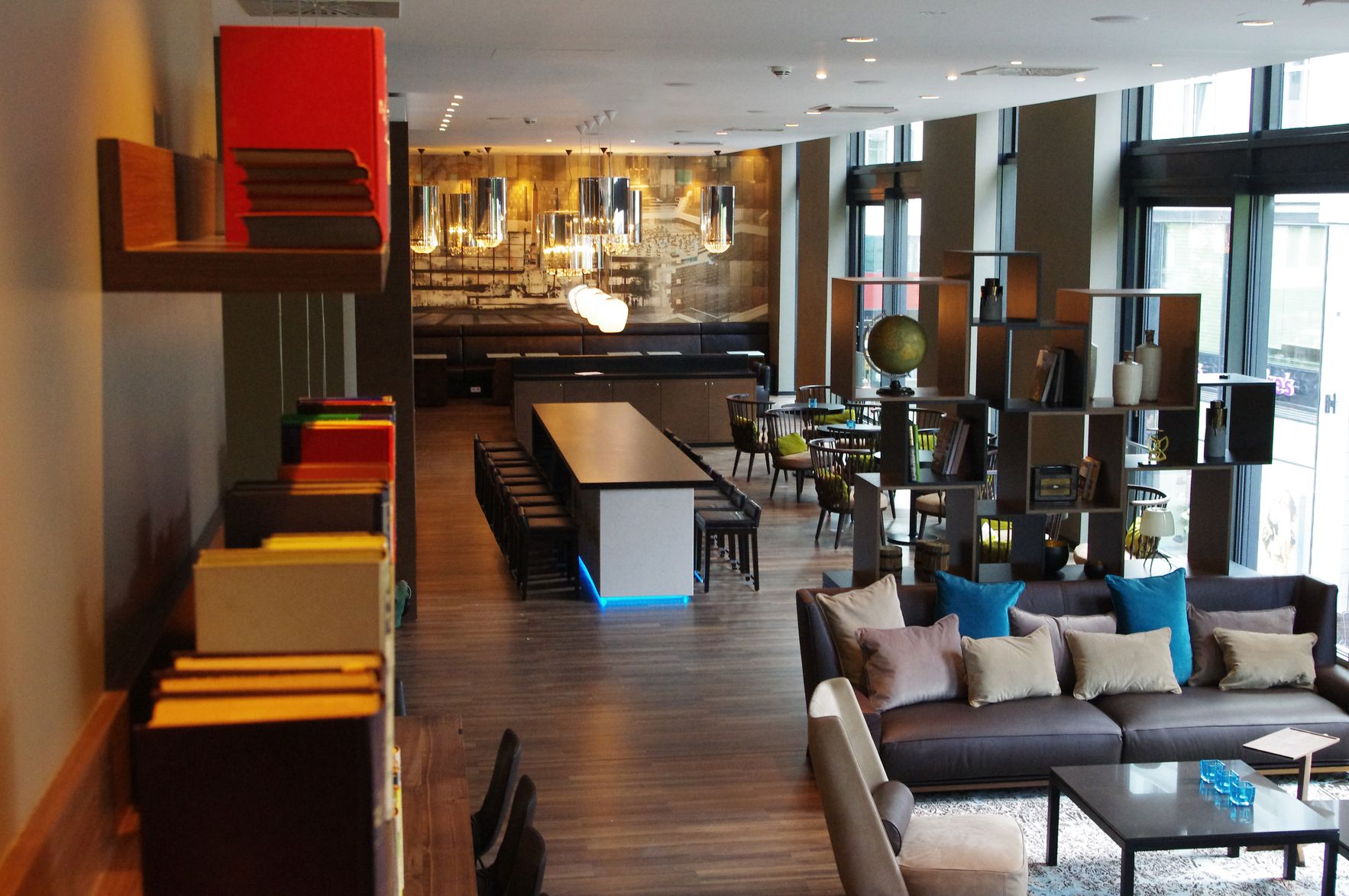 Designhotel Leipzig Augustusplatz Motel One Blick von oben in lichtdurchflutete Lounge mit mehreren Sitzgelegenheiten
