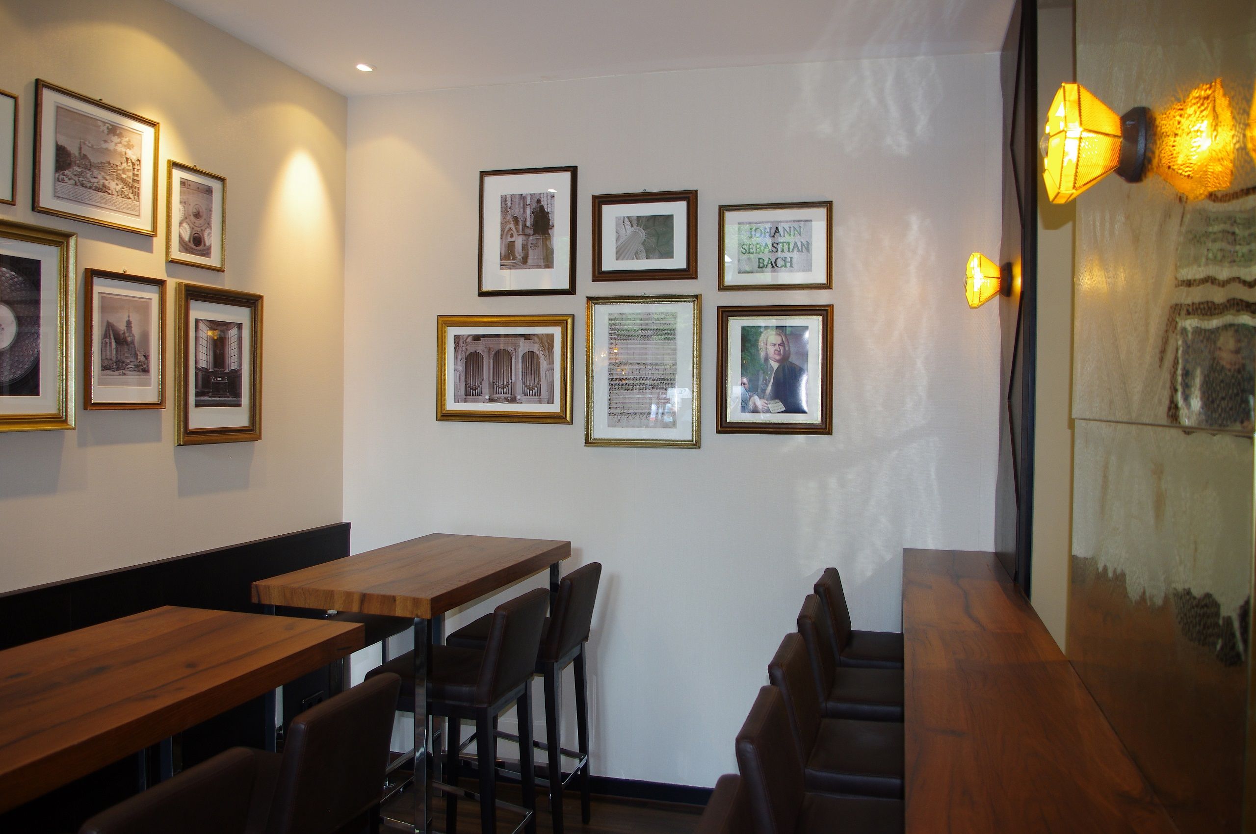 Hotel Leipzig Augustusplatz Motel One Hochtische und Stühle mit mehreren Bildern an der Wand