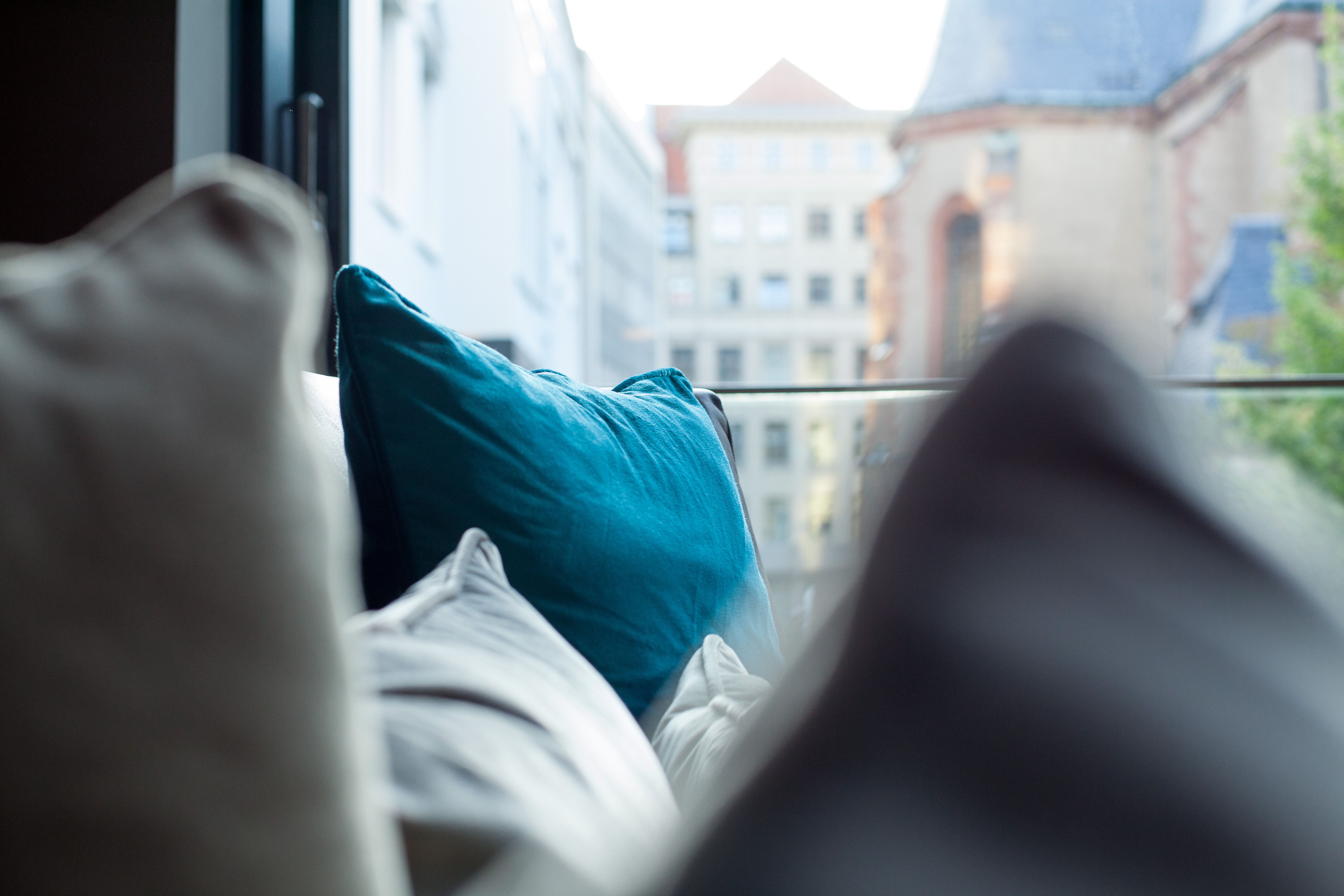 Hotel Leipzig Augustusplatz Motel One Nahaufnahme Kissen auf einer Couch vor großem Fenster