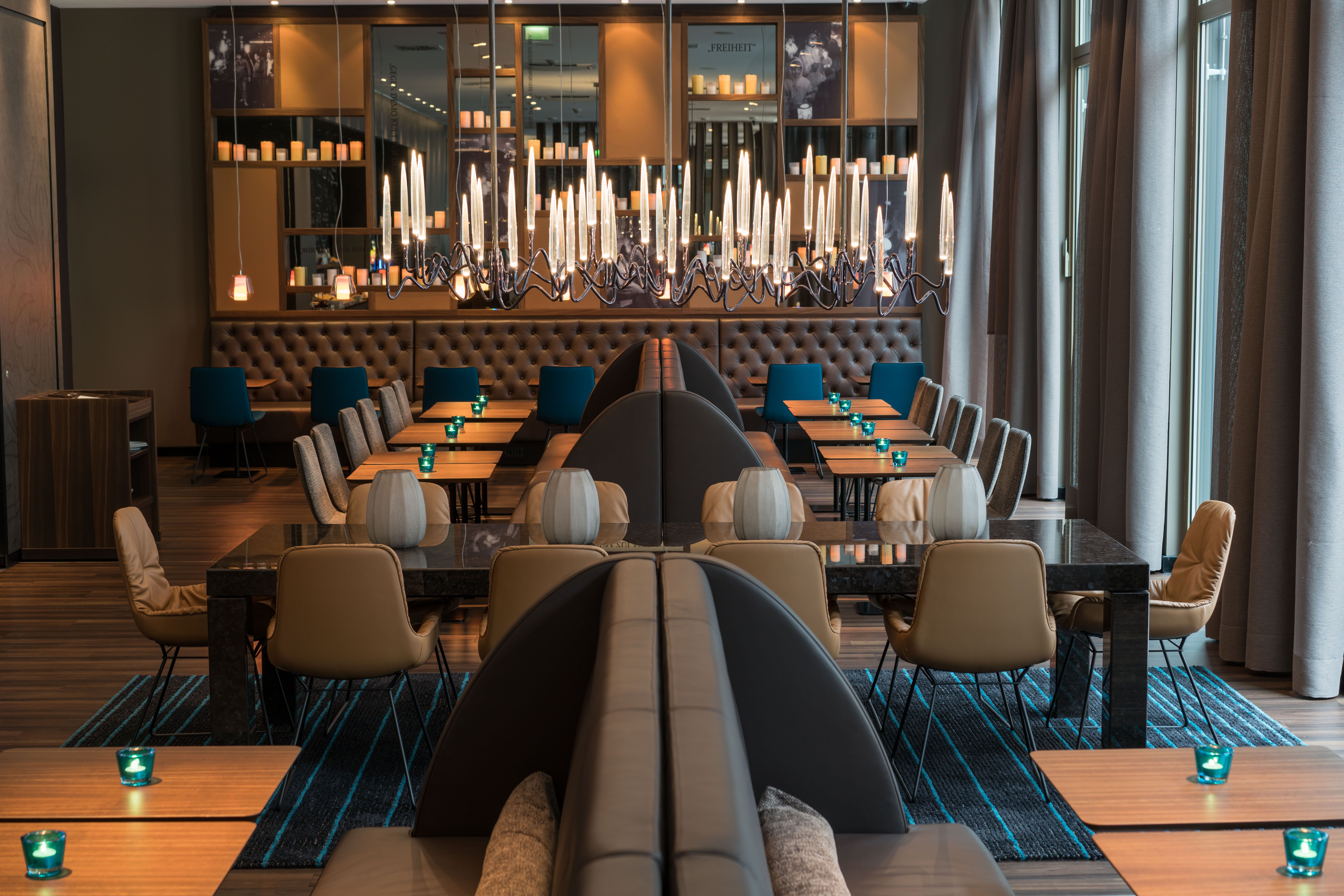 Hotel Leipzig Nikolaikirche Motel One Blick auf Tische und Stühle in lichtdurchflutetem Raum