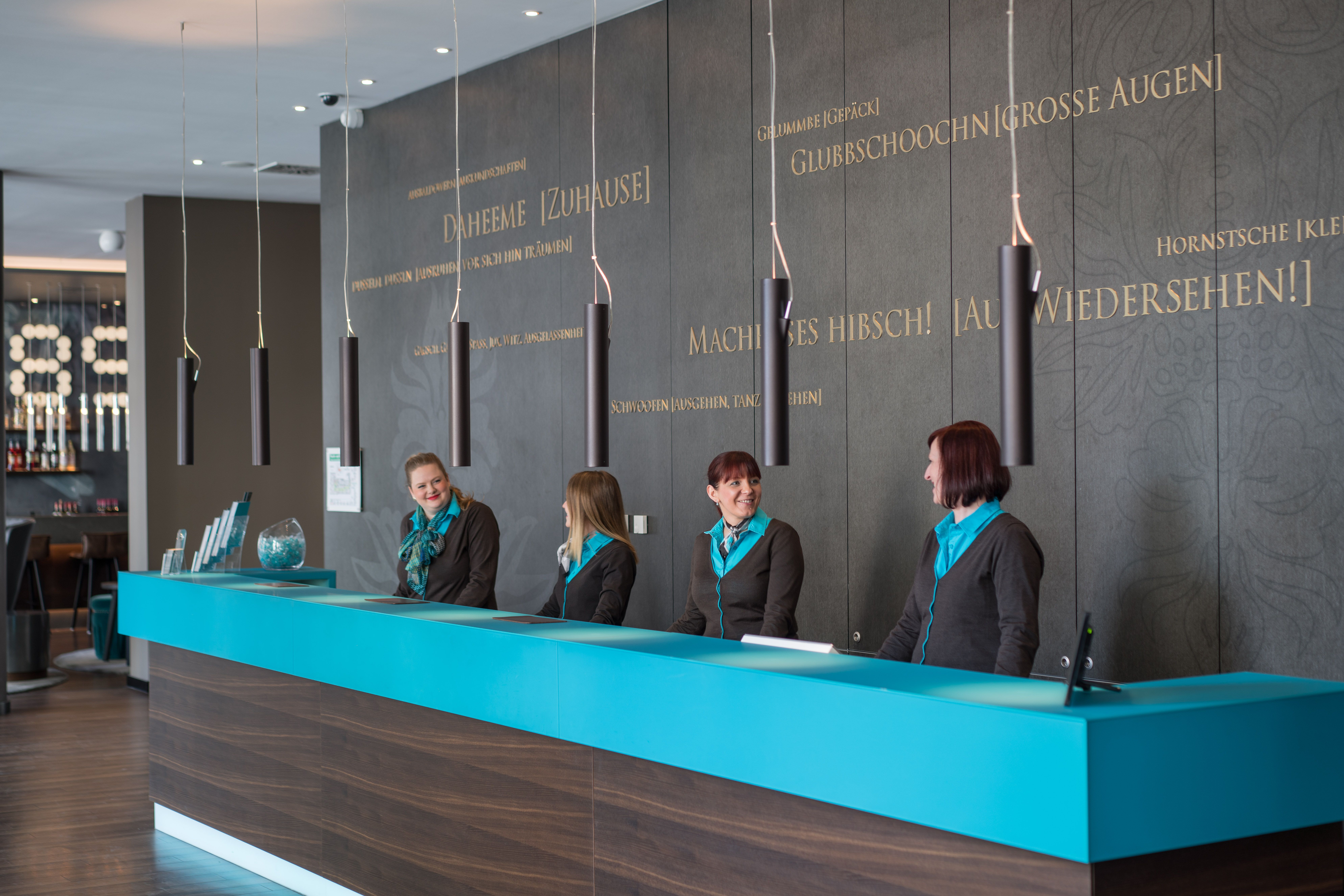 Hotel Leipzig Nikolaikirche Motel One Rezeption mit vier Mitarbeiterinnnen