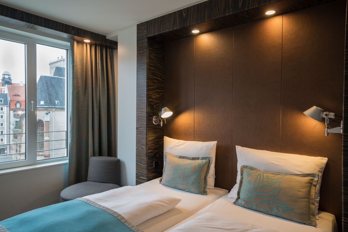 Designhotel Leipzig Nikolaikirche Motel One helles Zimmer mit großem Bett und Aussicht auf die Stadt