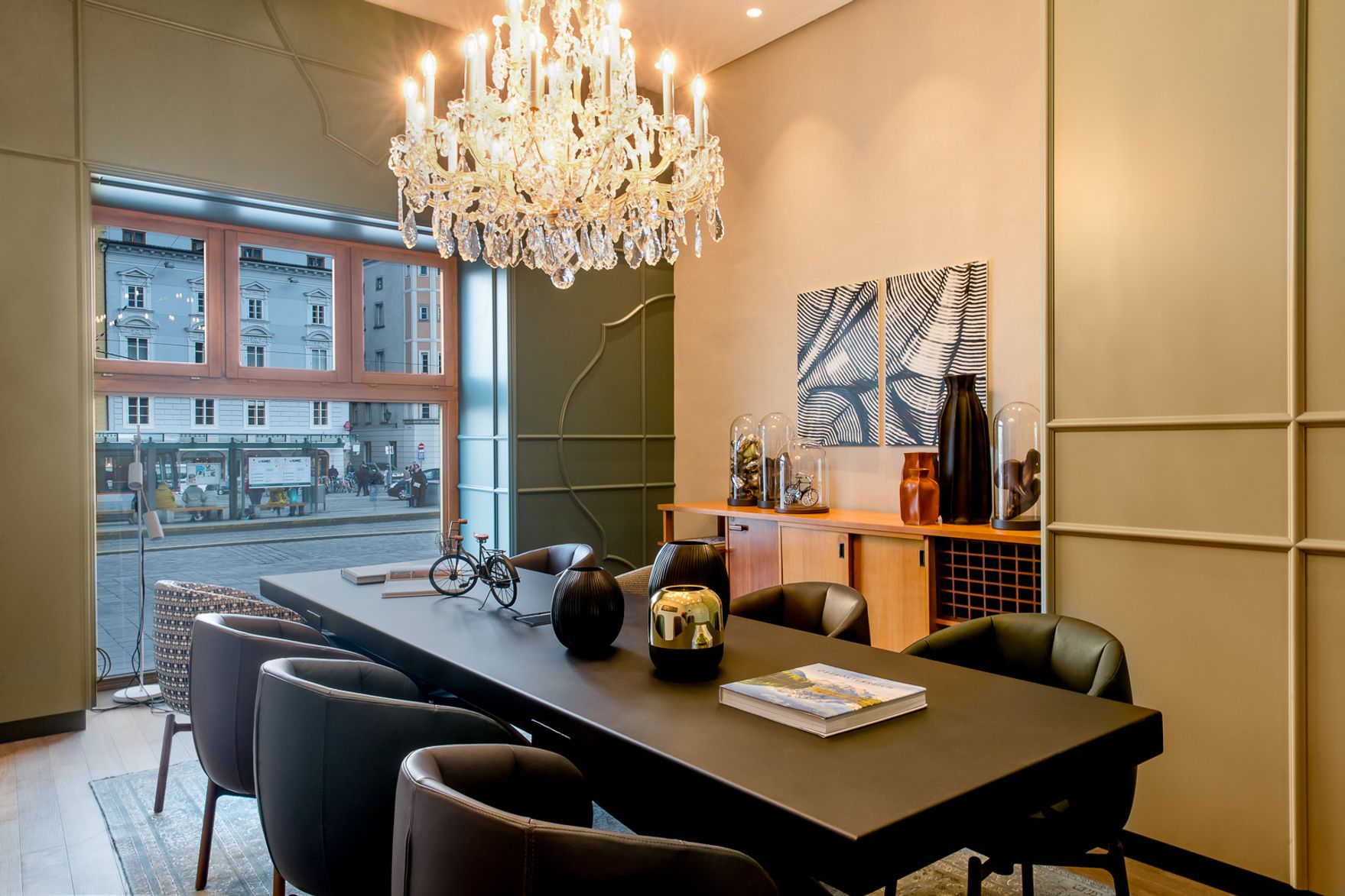 designhotel Linz Hauptplatz Motel One long table with eight chairs in front of a floor-to-ceiling window