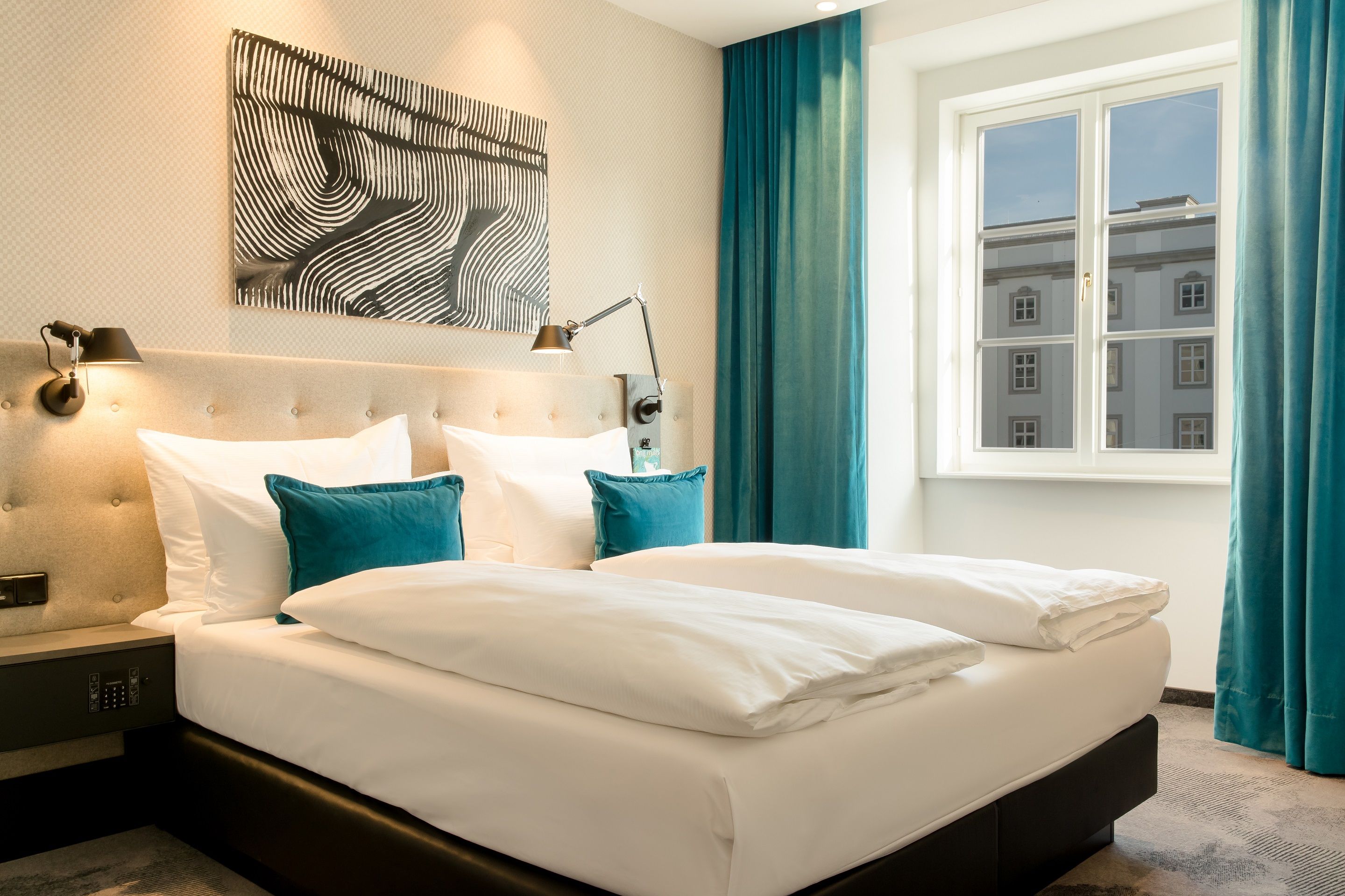 Designhotel Linz Hauptplatz Motel One warmes Zimmer mit Sonneneinstrahlung und großem Doppelbett